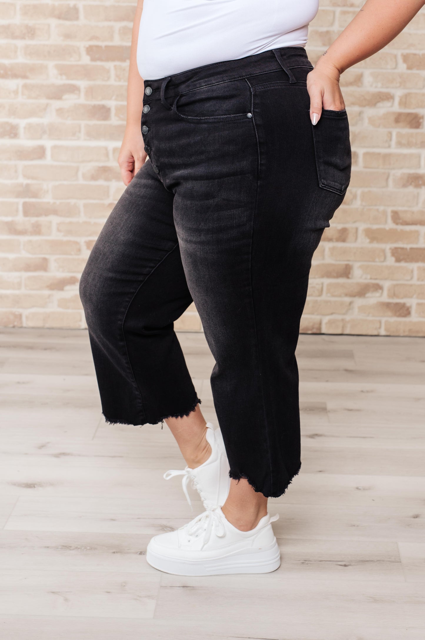 Get ready to rock stylishly with Ryan High Rise Jeans! These wide leg crop jeans feature a coordinating button fly and a washed out black garment dye for a cool, edgy look. With a high rise and raw hem, you'll stand out in the best way possible. 0-24W