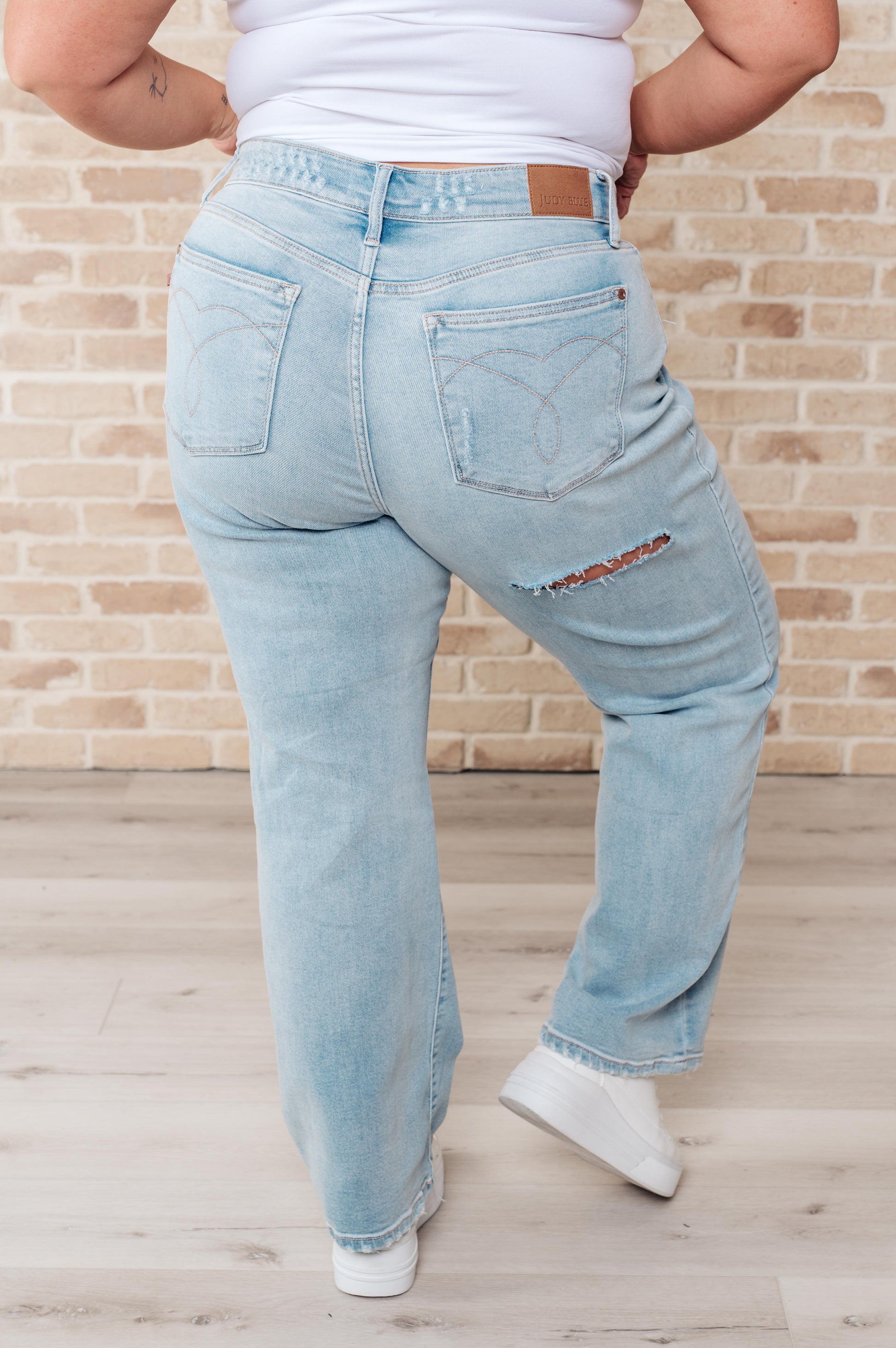 Rock the hottest trend with the Parker High Rise 90's Straight Jeans! Featuring a light wash and distressed front and back, these jeans offer a unique and stylish look. Their high rise and 90's straight silhouette provide a flattering fit for any body type. Upgrade your wardrobe with these must-have jeans! 0-24W