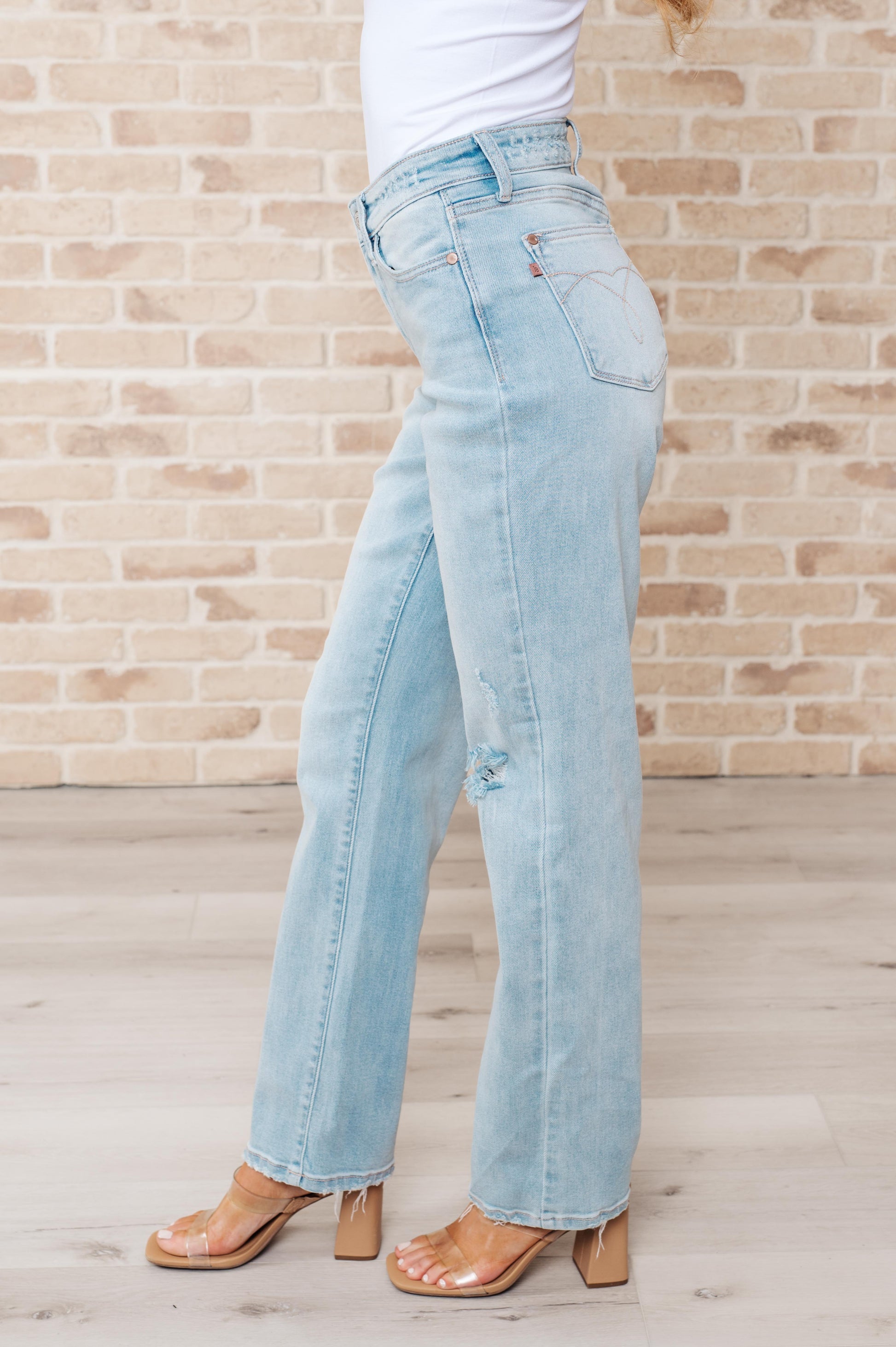 Rock the hottest trend with the Parker High Rise 90's Straight Jeans! Featuring a light wash and distressed front and back, these jeans offer a unique and stylish look. Their high rise and 90's straight silhouette provide a flattering fit for any body type. Upgrade your wardrobe with these must-have jeans! 0-24W