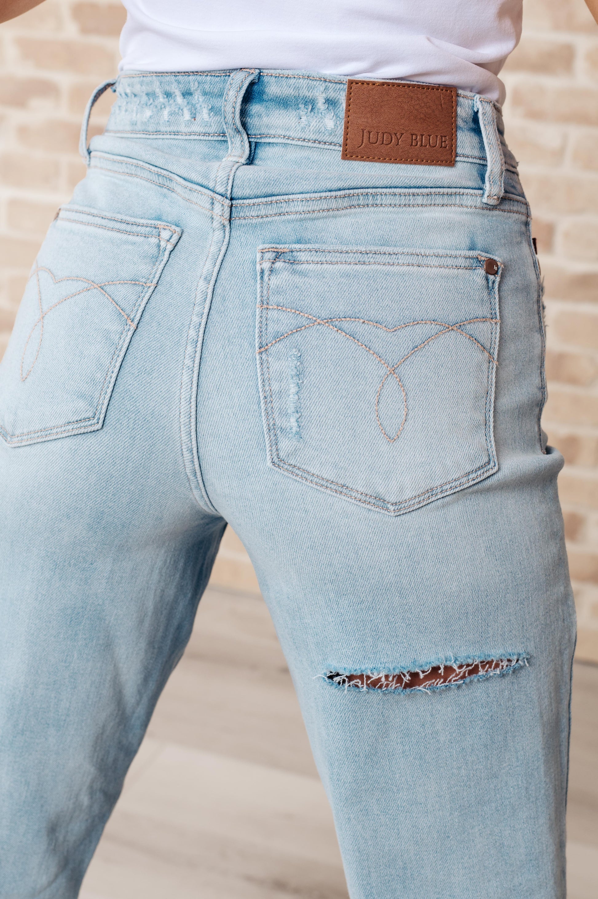 Rock the hottest trend with the Parker High Rise 90's Straight Jeans! Featuring a light wash and distressed front and back, these jeans offer a unique and stylish look. Their high rise and 90's straight silhouette provide a flattering fit for any body type. Upgrade your wardrobe with these must-have jeans!