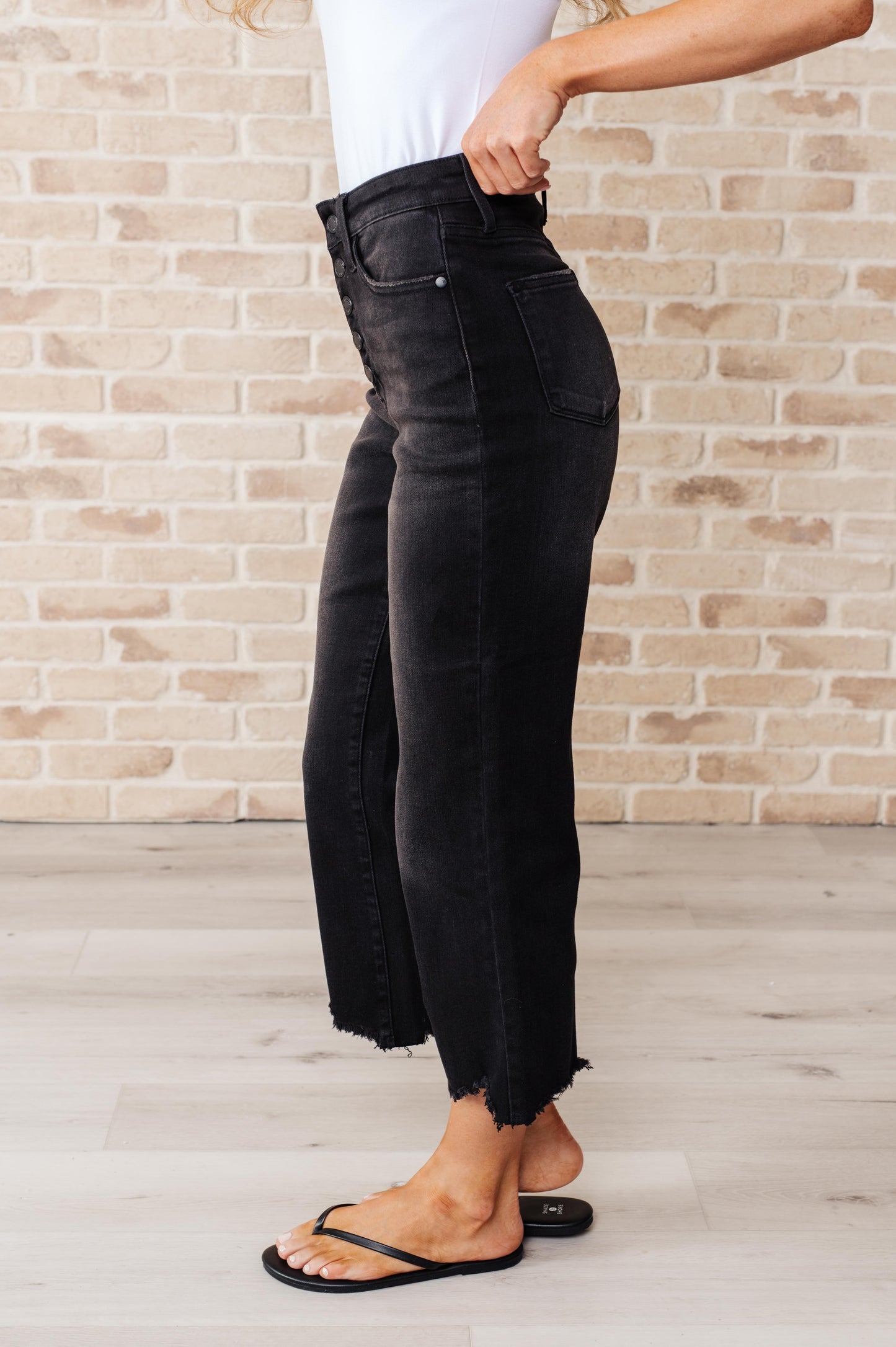 Get ready to rock stylishly with Ryan High Rise Jeans! These wide leg crop jeans feature a coordinating button fly and a washed out black garment dye for a cool, edgy look. With a high rise and raw hem, you'll stand out in the best way possible. 0-24W