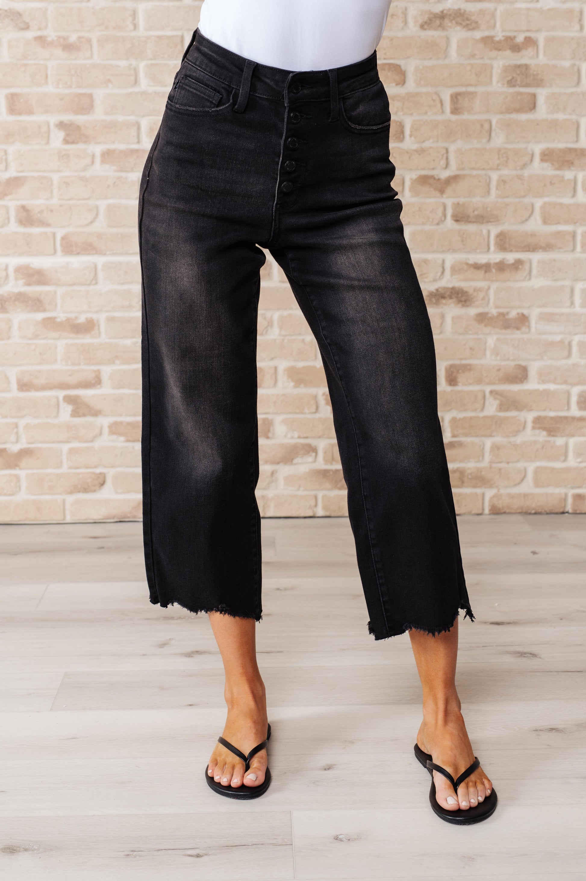 Get ready to rock stylishly with Ryan High Rise Jeans! These wide leg crop jeans feature a coordinating button fly and a washed out black garment dye for a cool, edgy look. With a high rise and raw hem, you'll stand out in the best way possible.  0-24W