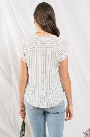 Feel flirty and fun in our Zig Zag Top! This cute top has an eye catching lace trim round neckline, extended shoulders, and dolman sleeves with lace trim. Plus, the front lace inset detail and back non-functional buttons will keep heads turning! Who says fashion can't be playful? Sashay into the room in this statement piece!
