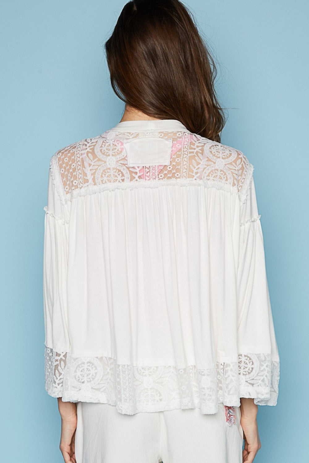 The designed open front oversized fit cardigan with 3/4 length bell sleeves is a chic layering piece for any outfit. Crafted from a mix of jersey and lace, this cardigan combines comfort with a touch of elegance. The frayed edge detail on the entire garment adds a contemporary and edgy vibe, giving it a unique and textured look. S-L