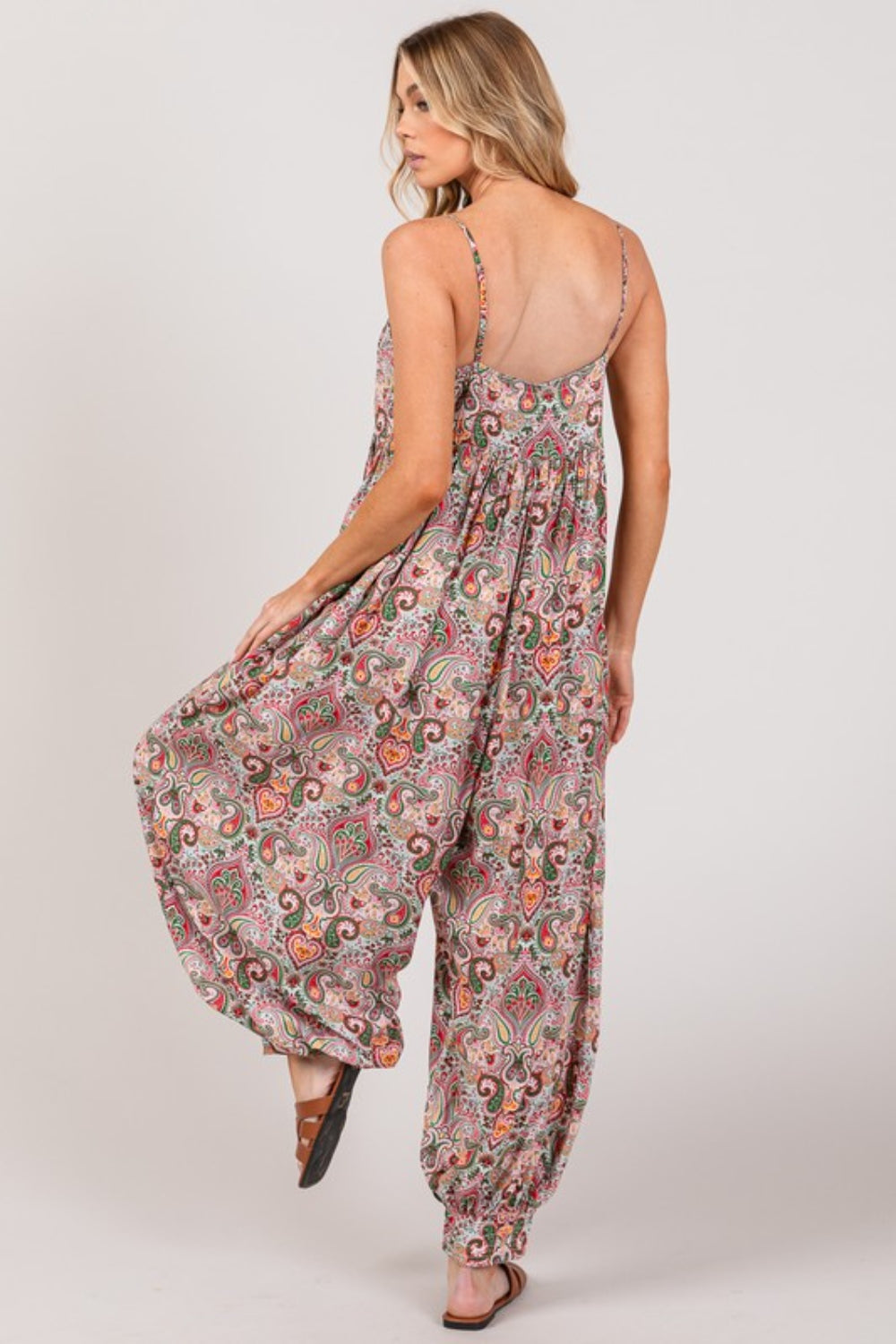 The Multi Paisley Print Sleeveless Jumpsuit is a chic and versatile piece that exudes bohemian charm. The colorful paisley print adds a pop of vibrancy and energy to the jumpsuit, making it a statement piece for any occasion. The sleeveless design and flowy silhouette offer a comfortable and flattering fit, perfect for warm weather or casual outings.  S-X