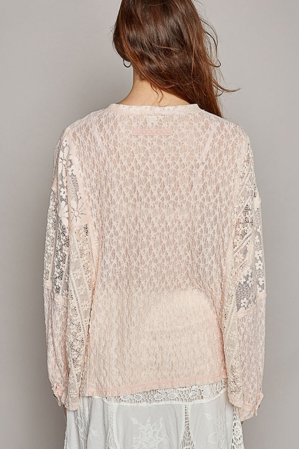 The round neck top with placket, straight sleeves, and a relaxed fit in acrylic sweater material is a cozy and stylish choice for cooler weather. The outseam edge detail and pointed solid pattern add a modern twist to the design, creating a chic and sophisticated look. S-L