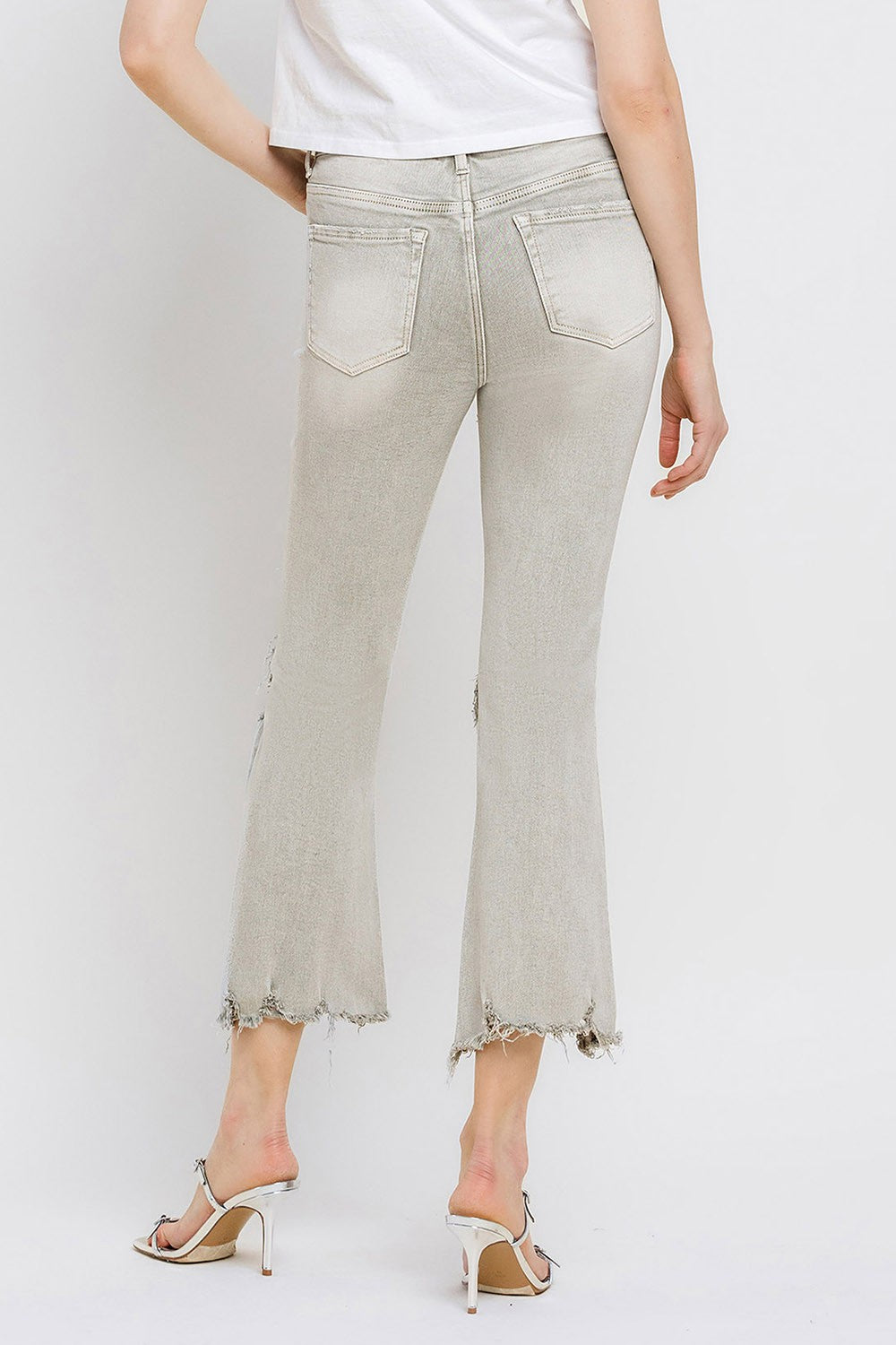 These distressed raw hem cropped flare jeans offer a perfect blend of edgy and retro style. The distressed detailing adds a touch of urban flair to the flared silhouette. The raw hem finishes off the look with a trendy, unfinished edge. Pair these jeans with a tucked-in graphic tee and platform sandals for a vintage-inspired outfit.