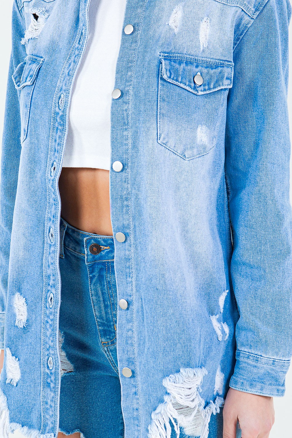 Introducing the Frayed Hem Distressed Denim Shirt Jacket. This stylish piece combines the timeless appeal of denim with a contemporary twist. The frayed hem adds a touch of edginess, while the distressed details create a worn-in look. S - 3X