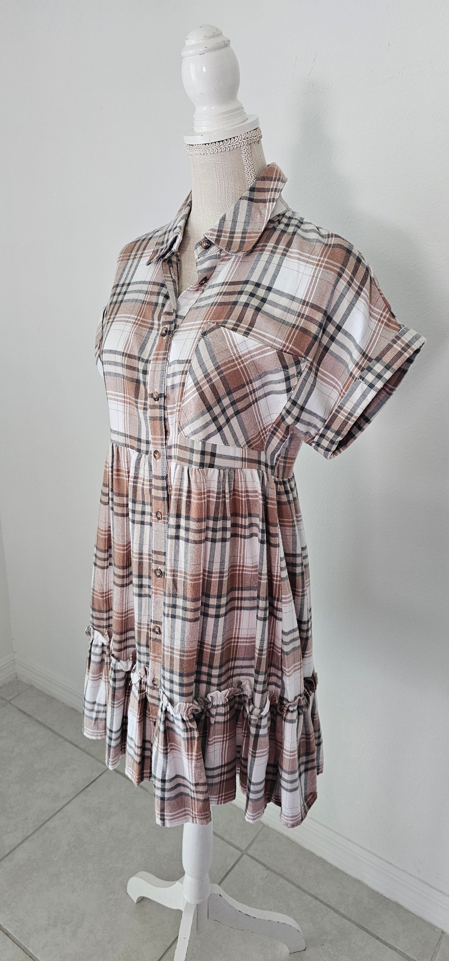 Rock your modern-meets-rustic side in this plaid mini dress! Featuring a collared neckline with button down closure, cinched waist, and a ruffle hem, you'll look fly af (as fashionable) no matter the occasion. With pocket detail, this pleated plaid piece will have you looking cute and stylish all day - yesssss girl! Sizes small through large.