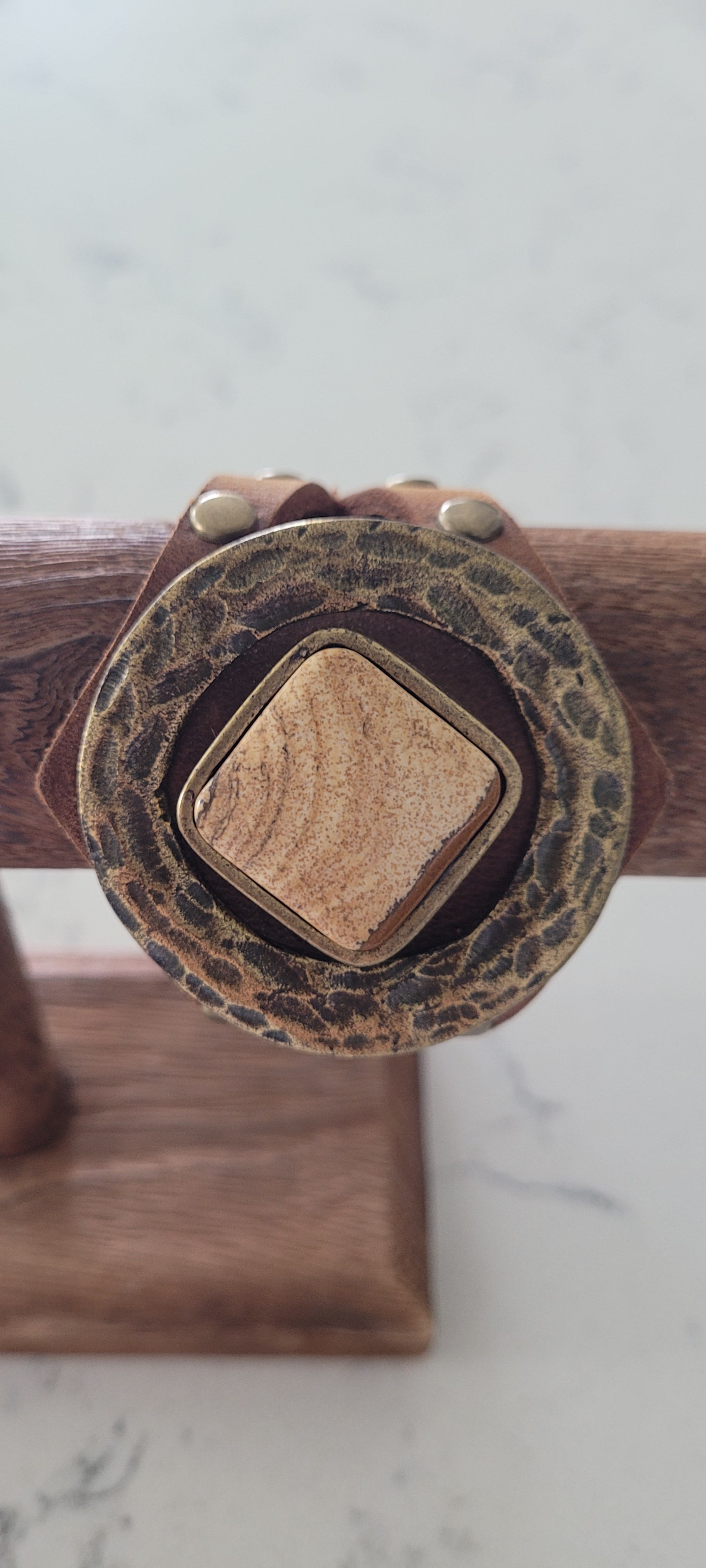 Semi-precious stone Accented with hardware and studs Genuine Leather Adjustable snap closure Color: chocolate brown Length: 8.5 inch Limited supply / one of a kind! Made in the USA