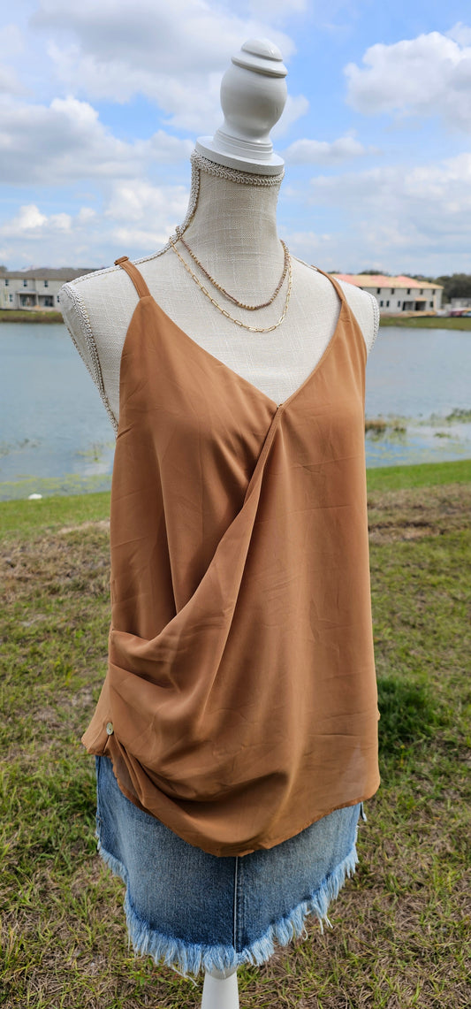 “Frappuccino” is a woven double layer chiffon top, featuring buttons up the side, surplice neckline, and adjustable spaghetti straps. This top is perfect for layering or great all by itself. Sizes small through x-large.