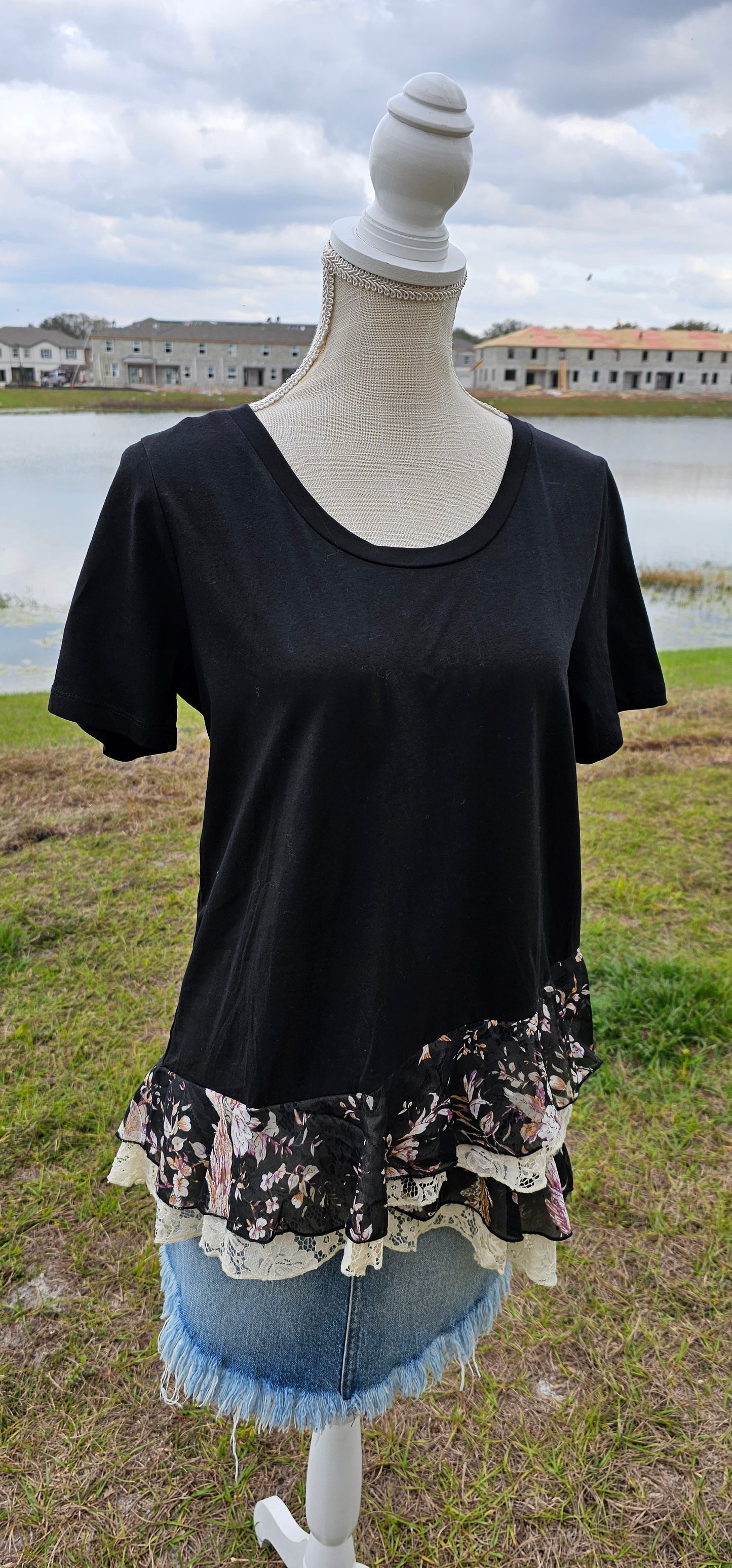 This is a comfy and casual black top, which features short sleeves, rounded neckline, layering lace and layering flowery print bottom. This is a great staple piece to your wardrobe. Sizes small through large.