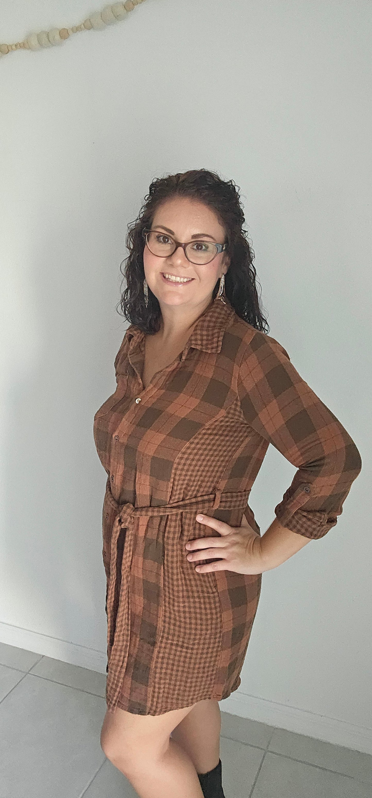 Step into autumn in style with the Riley Rust Plaid Shirt Dress! This warm plaid dress has all the details that make it a stand-out: buttoned front, tie-waist belt, plus functional chest and side pockets. Roll up the sleeves and get ready to kick up some fallen leaves. It's sure to get you noticed! Sizes small through large.