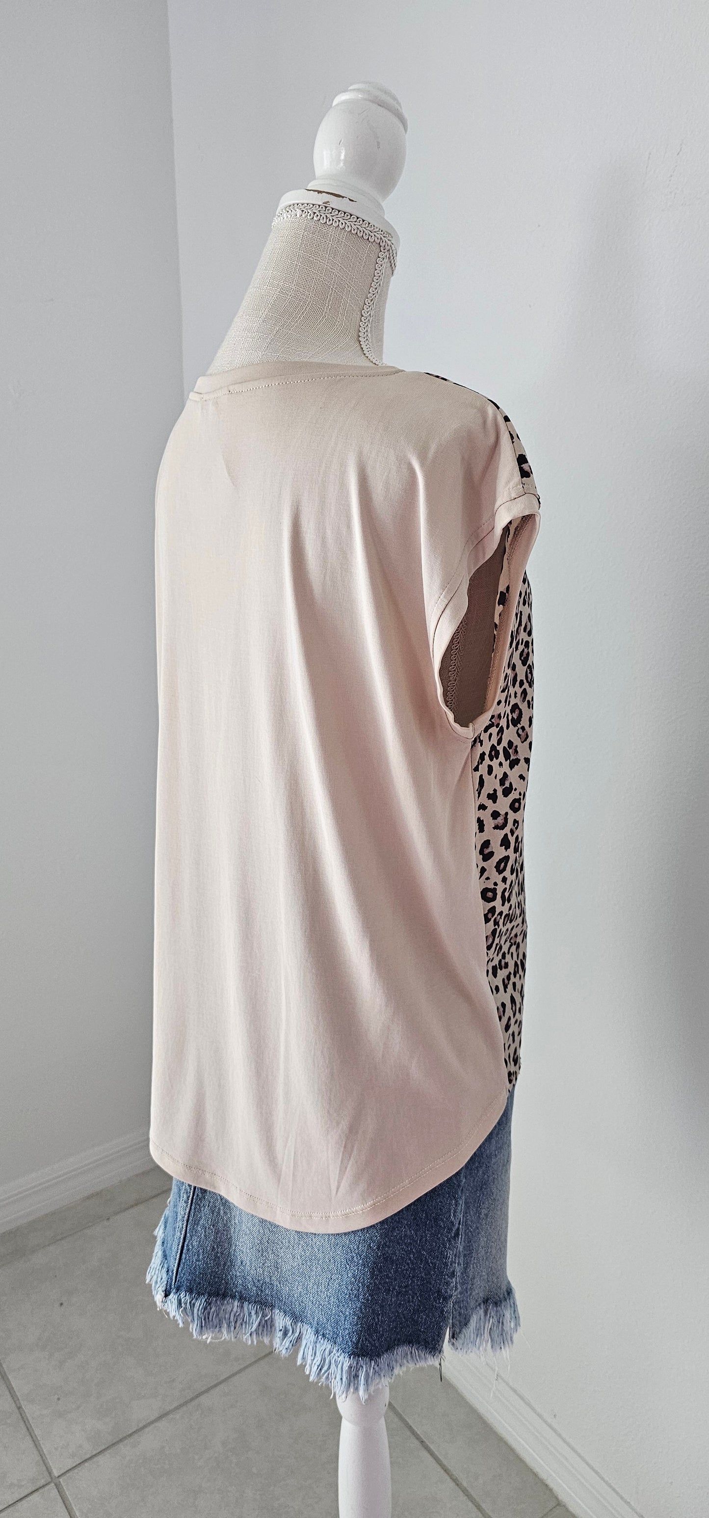 “Road Less Traveled” is a sleeveless top, with leopard print front (beige, brown, camel, agreeable gray) and contrast back, boat neckline, trimmed with beige soft modal, and rounded hemline. This is a satiny, silky soft high-low top. This is definitely a business or casual top. Sizes small through large.
