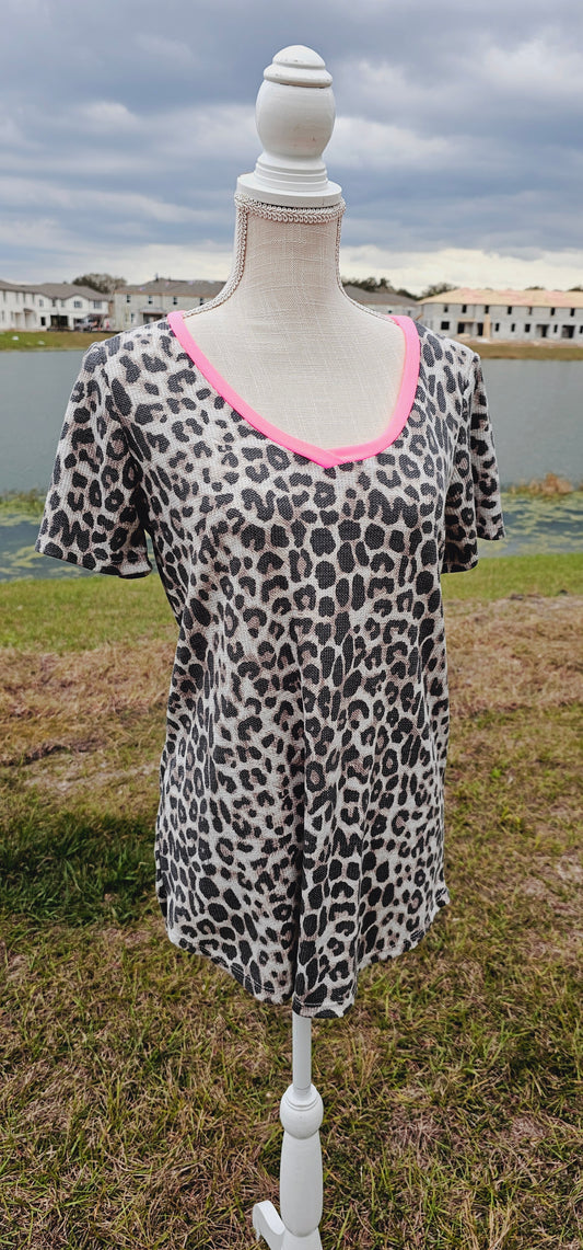 “Pixie Dust” is a comfy and casual t-shirt! This is a short sleeve shirt, featuring leopard print with a hot pink v-neck, waffle knit, and rounded hemline. Pair with your favorite pair of denim jeans, shorts, or skirt. Don’t be afraid to get creative! Sizes small through large.