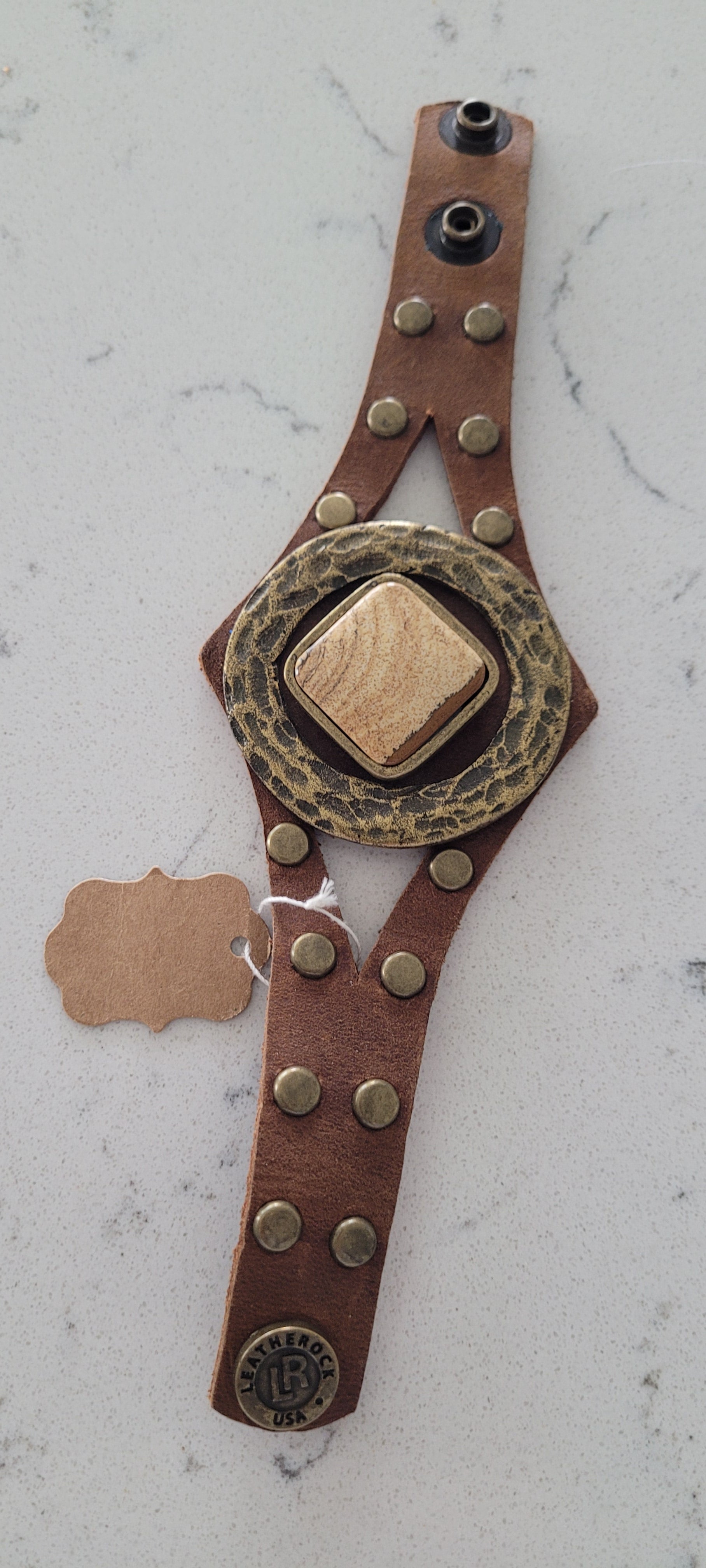 Semi-precious stone Accented with hardware and studs Genuine Leather Adjustable snap closure Color: chocolate brown Length: 8.5 inch Limited supply / one of a kind! Made in the USA