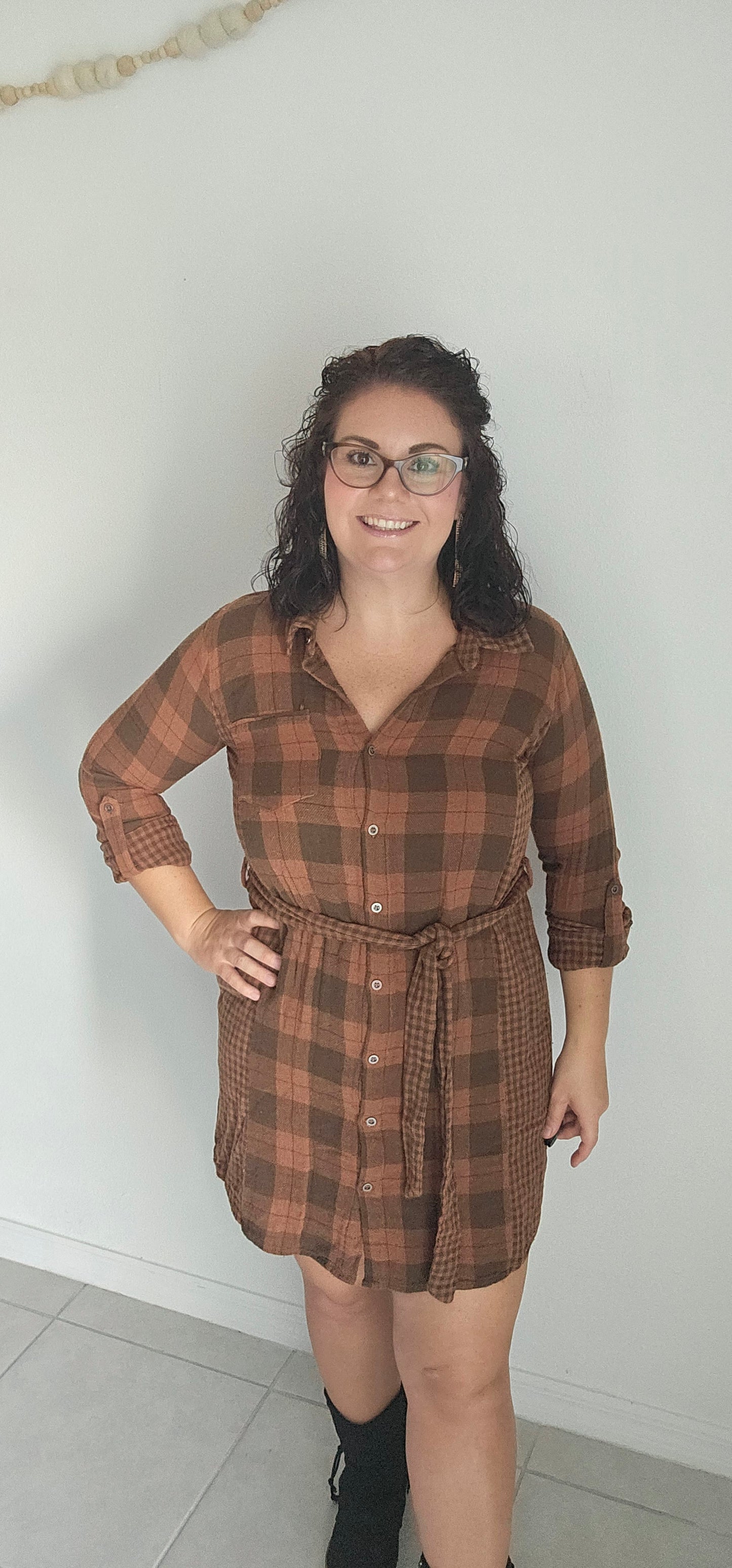 Step into autumn in style with the Riley Rust Plaid Shirt Dress! This warm plaid dress has all the details that make it a stand-out: buttoned front, tie-waist belt, plus functional chest and side pockets. Roll up the sleeves and get ready to kick up some fallen leaves. It's sure to get you noticed! Sizes small through large.