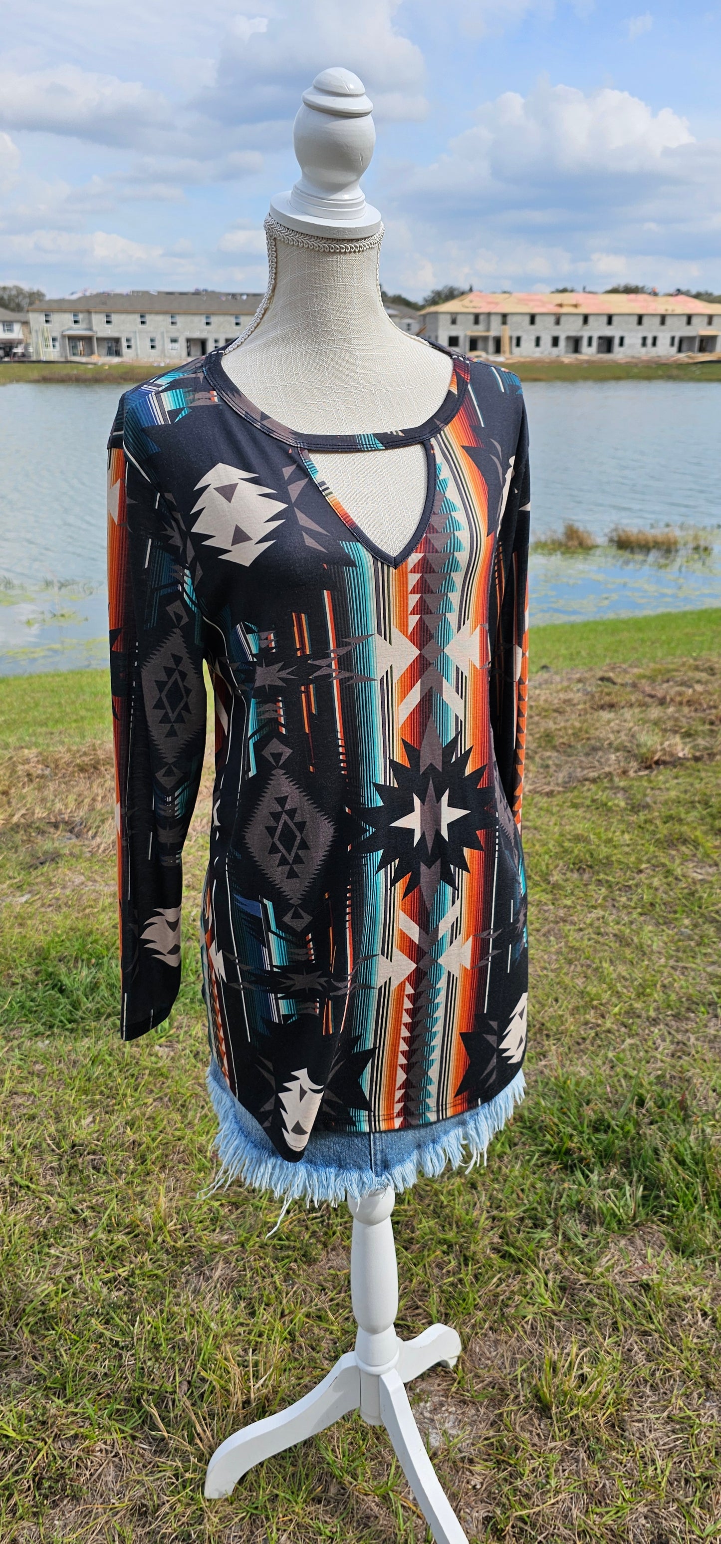 This is a comfy and casual long sleeve top. It features a rounded neckline with a V shaped cutout, long sleeves, Aztec design. Imagine yourself going to the rodeo, or line dancing. Whatever your adventure is, this is the shirt! Sizes small through x-large.