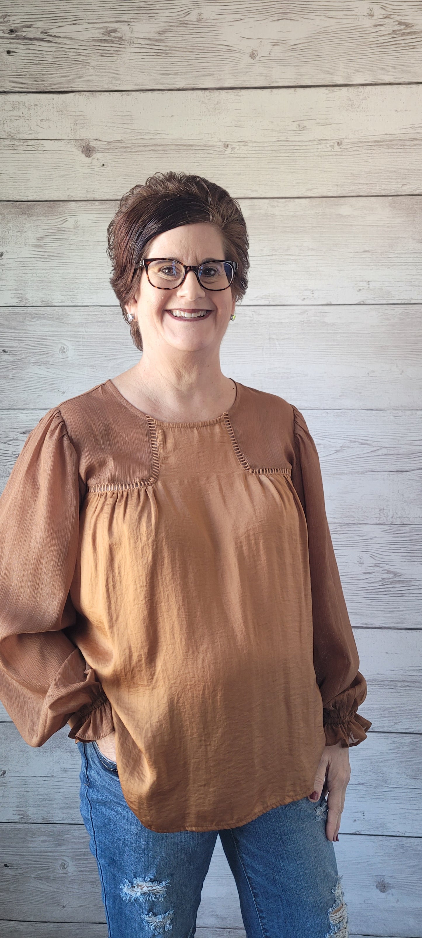 Feel like royalty in our Sophia Camel Satin Blouse! With a round neck and keyhole back button closure, this top offers the perfect balance between style and comfort. Puff sleeves with gathered ruffles and ladder trim detail add a unique touch, as does the front and back shirring. Shine bright with your own golden thread of Lurex contrast! Sizes small through large.
