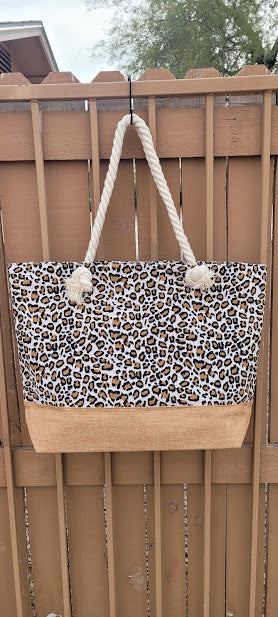 This leopard print tote features a cream color braided handle with a zipper top.  The material is polyester. The inside has a lining with a pocket for all of the small stuff that you do not want to get lost.  The outside bottom has a burlap color fabric. This tote is very versatile.  Imagine yourself heading to the beach, going shopping, or heading to the local market, you will get a lot of use out of this super cute tote.