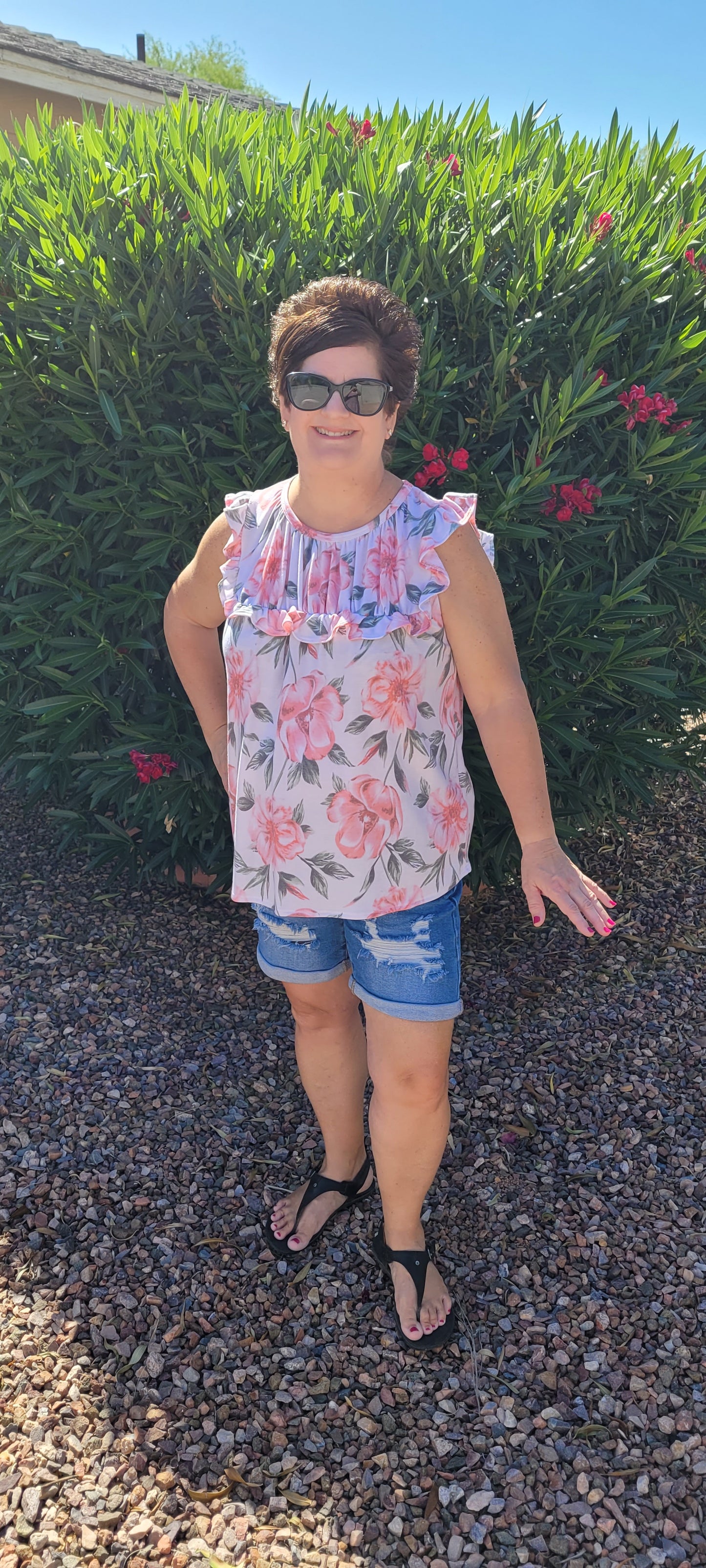 “Garden Goddess” is a comfy and casual top! This sleeveless white shirt features a beautiful pink and sage floral print. It is a baby doll top with rounded neckline, ruffled details on sleeves and chest. This top is so soft and comfy! There is a terry cloth texture inside. Sizes small through large.