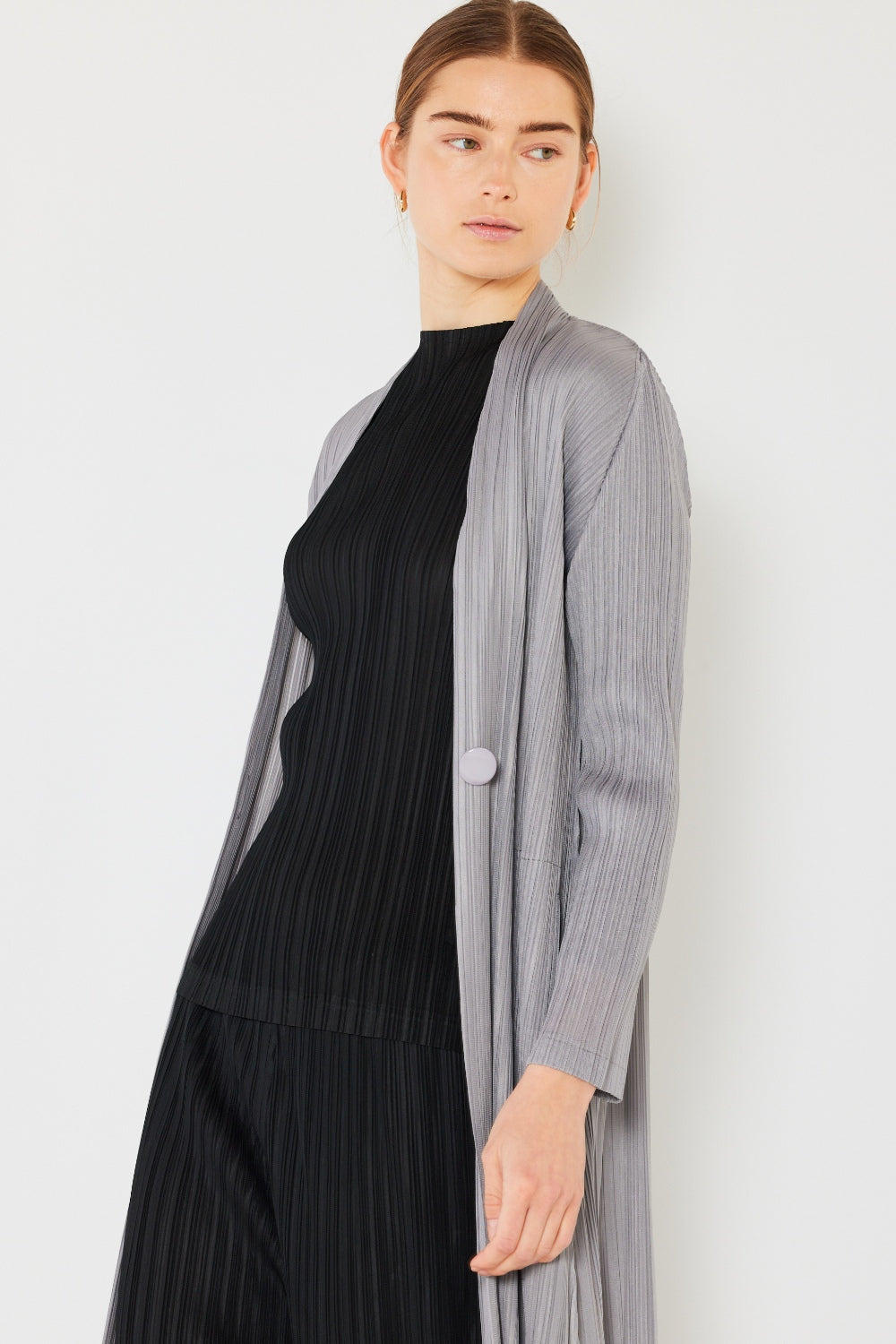 The Pleated Long Sleeve Cardigan is a versatile and chic layering piece for your wardrobe. With its pleated detailing and long sleeves, this cardigan offers a stylish and sophisticated look. The pleats add texture and visual interest to the classic cardigan design.