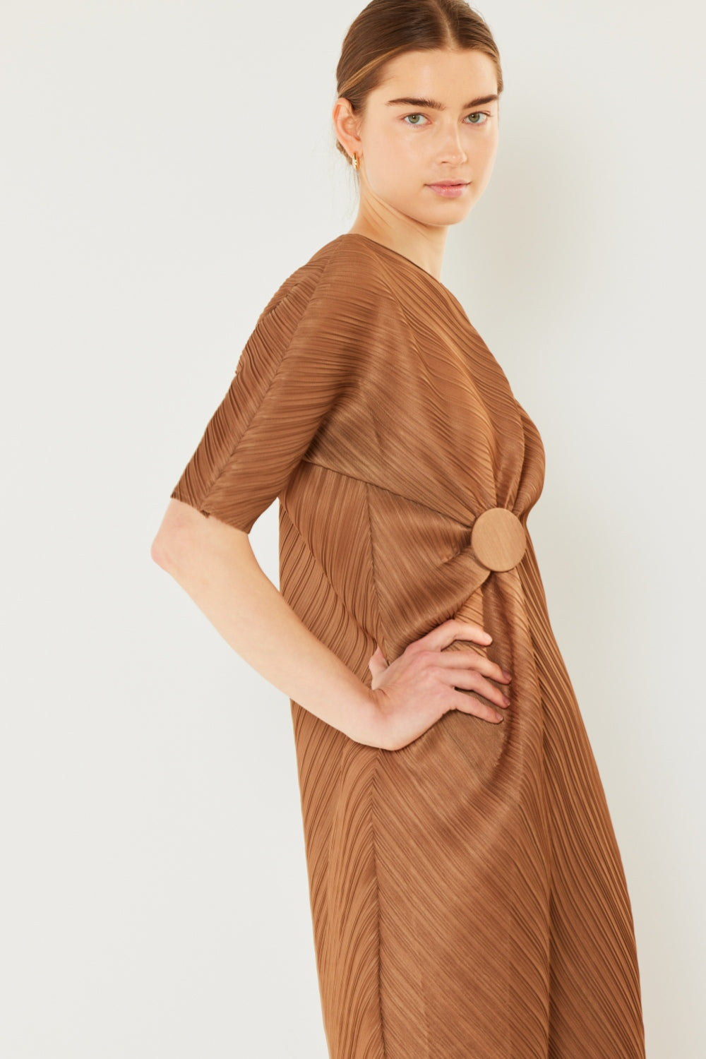 The Pleated Dolman Sleeve Dress is a modern and chic addition to your wardrobe. With its unique dolman sleeves and pleated detailing, this dress offers a stylish and sophisticated look. The relaxed silhouette and pleats create a flattering and comfortable fit.