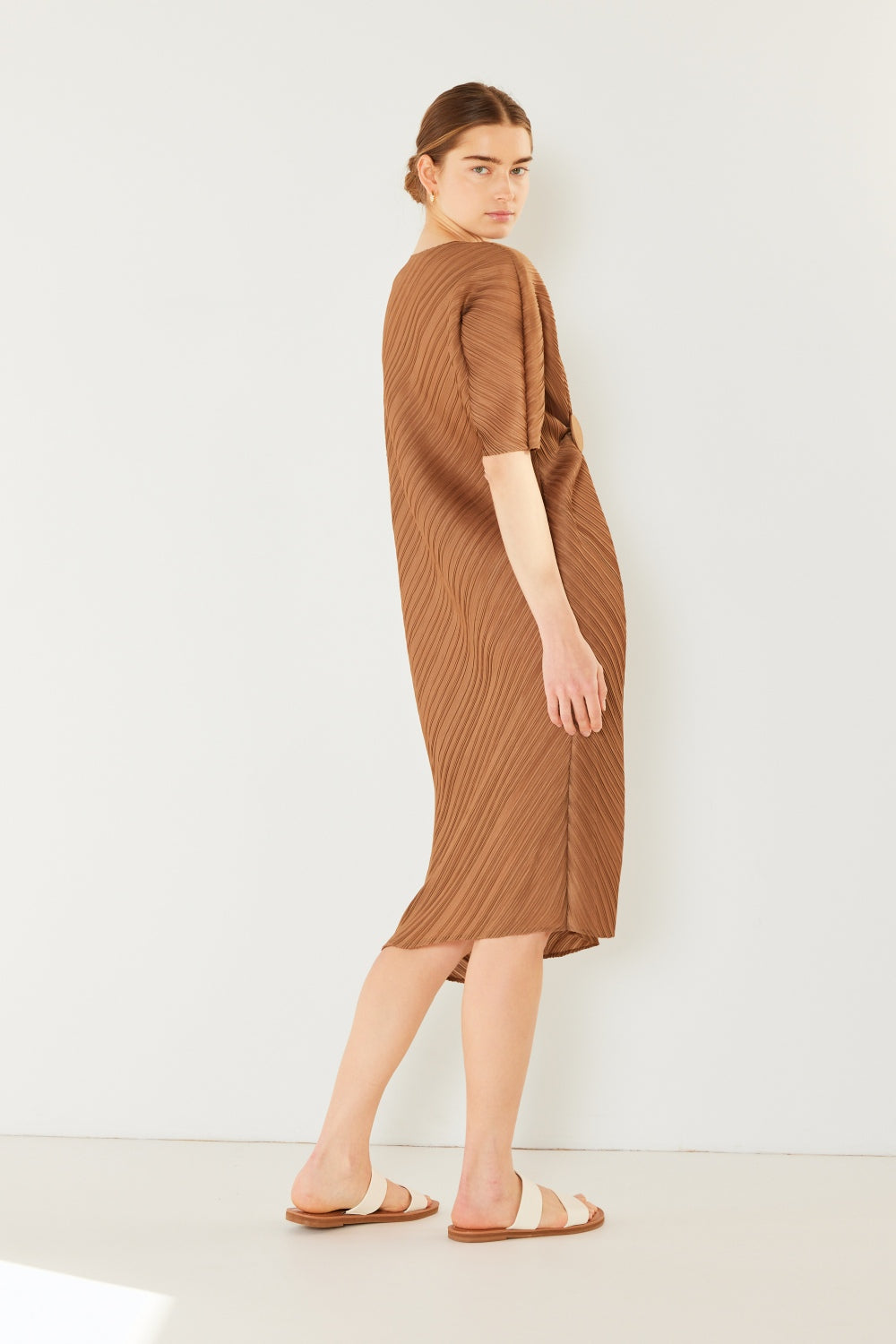 The Pleated Dolman Sleeve Dress is a modern and chic addition to your wardrobe. With its unique dolman sleeves and pleated detailing, this dress offers a stylish and sophisticated look. The relaxed silhouette and pleats create a flattering and comfortable fit.