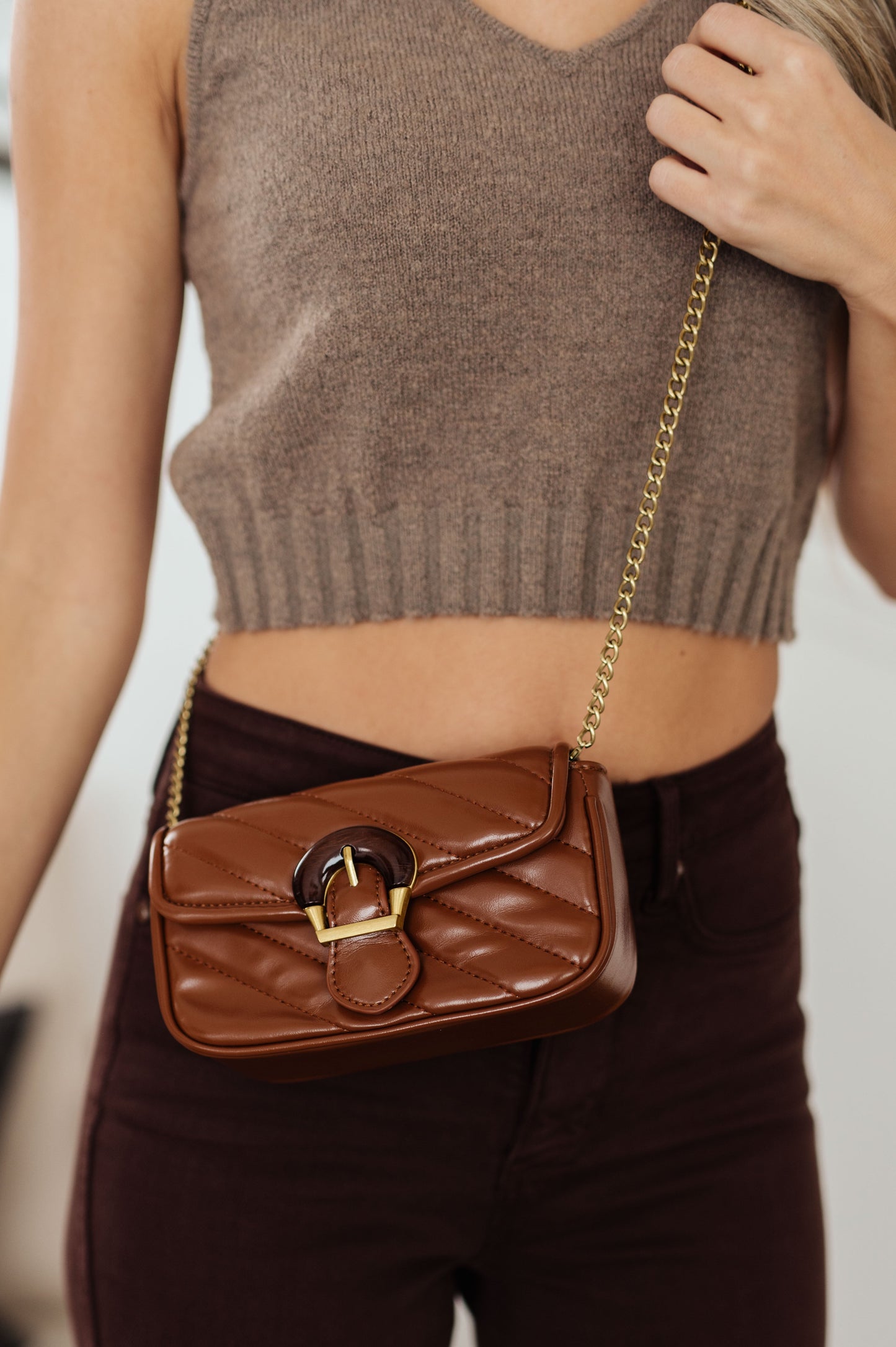 This beautiful Classic Beauty Quilted Clutch is timelessly chic in brown. With its quilted design, decorative wood buckle, magnetic clasp closure, and chain strap, it's the perfect accessory for any elegant event. Upgrade your look with this classic clutch!
