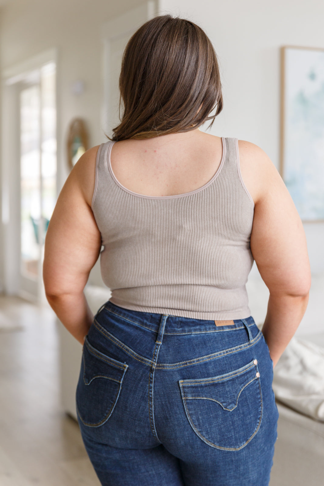 This tank is the perfect combination of function and fashion. Crafted from ribbed fabric with a seamless finish, it offers a flattering, cropped fit that can be customized with your choice of v-neck or scoop neck. Plus, its mineral wash makes it a true stand-out piece. S - 3X