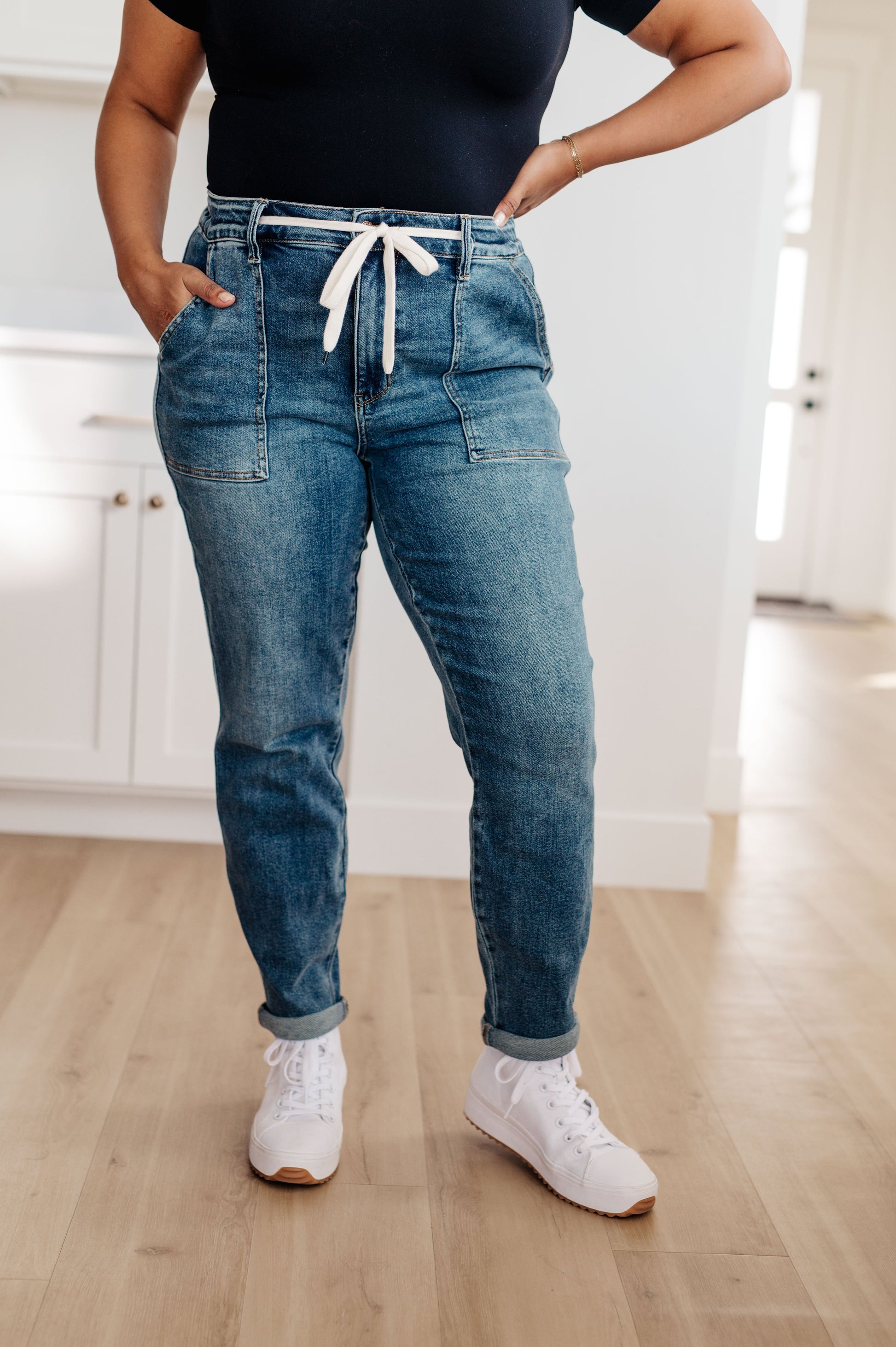 Experience the perfect fit and style in the Payton Pull-On Denim Joggers from Judy Blue! Made with a high rise and zero distressing, these medium-wash joggers offer an elastic waistband, functional drawstring, and patch pockets for a comfortable, adjustable fit. With an optional rolled cuff, you'll look and feel effortlessly chic. Are you ready to feel confident and stylish? Try Payton Pull-On Denim Joggers today!  0 -24W