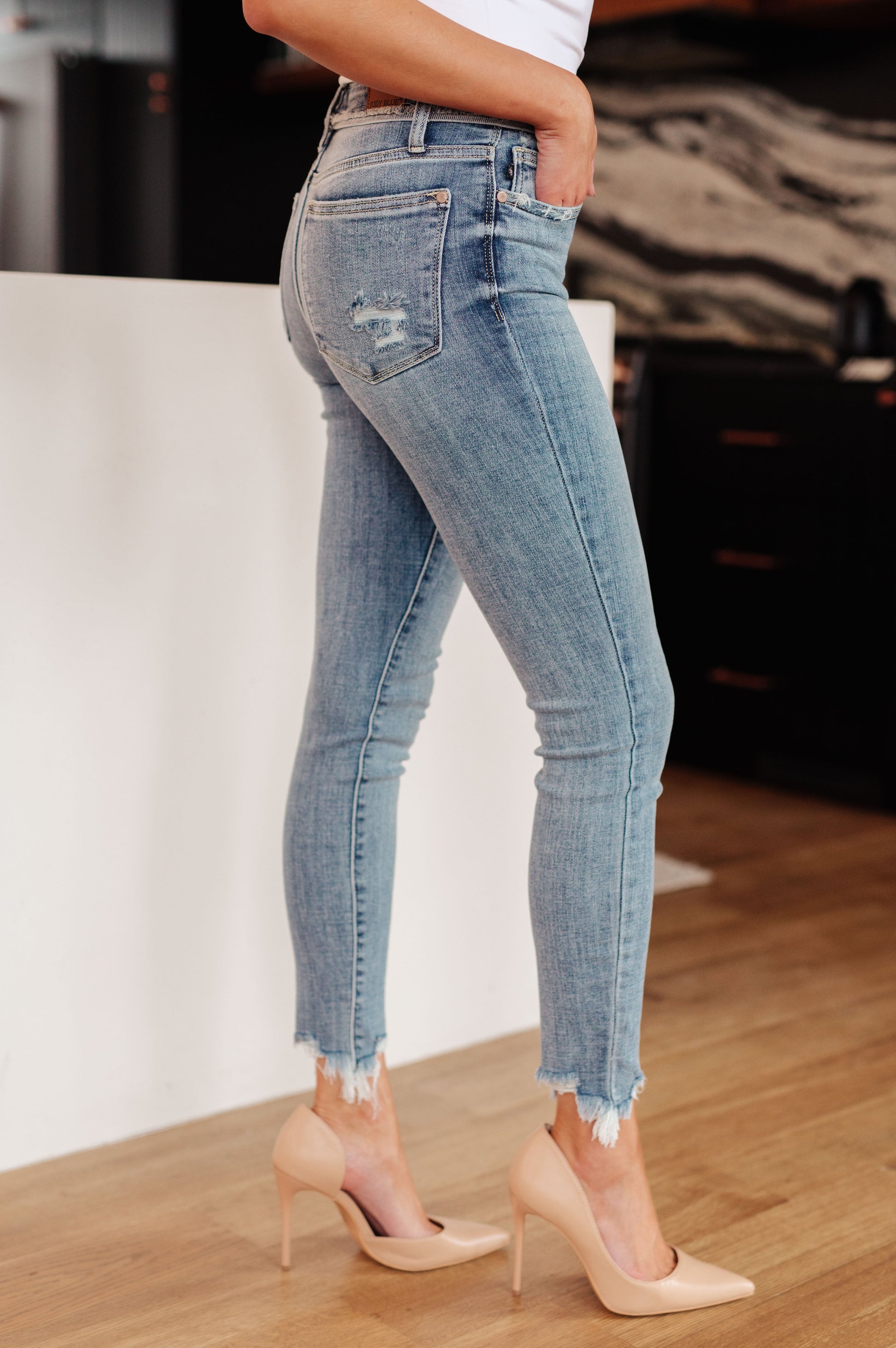 The Sherry Mid Rise Release Waistband Detail Skinny from Judy Blue are perfect for everyday style. Featuring a medium wash, flattering mid rise fit, and raw edge release waistband detail that all come together for a look that is casual and modern. The skinny fit and raw hemline complete the look.