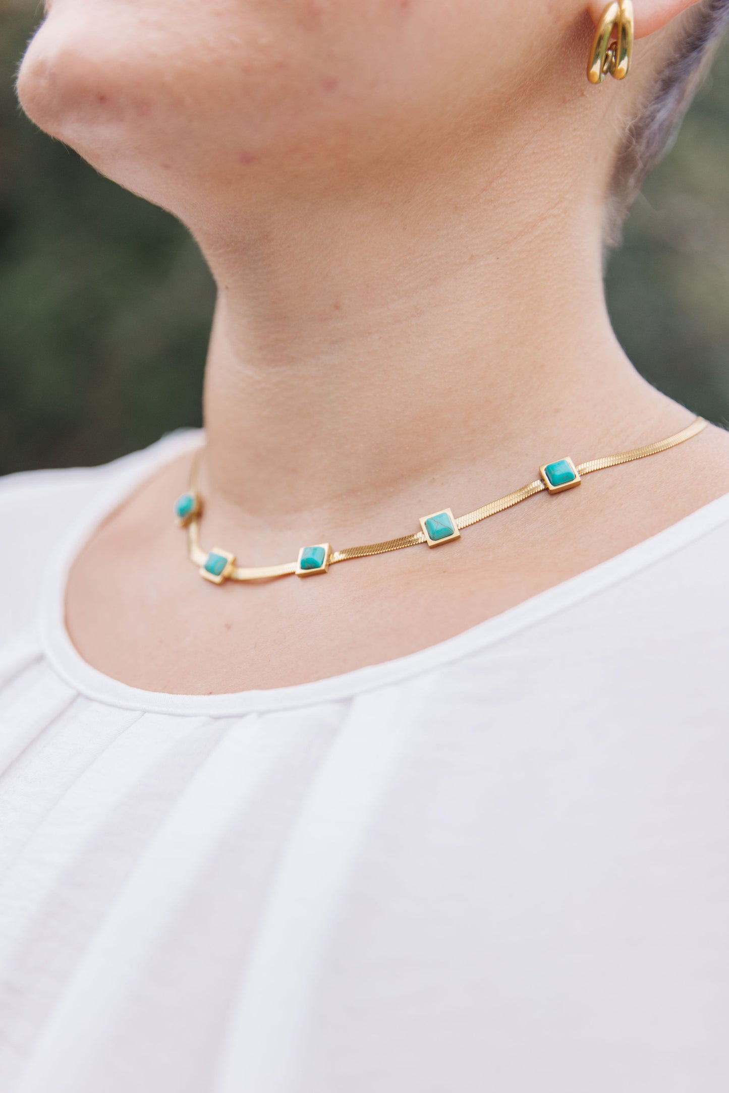 This Turquoise Squares Necklace is the perfect combination of modern and classic. The five fixed turquoise squares are set against a gold herringbone necklace, for a look that expertly combines timeless and trendy. Wear it to your next party and be the star of the night! 18K gold plated stainless steel means you can wear this piece to the beach, the pool, or even working out without worrying over tarnishing, green marks, or skin irritation.