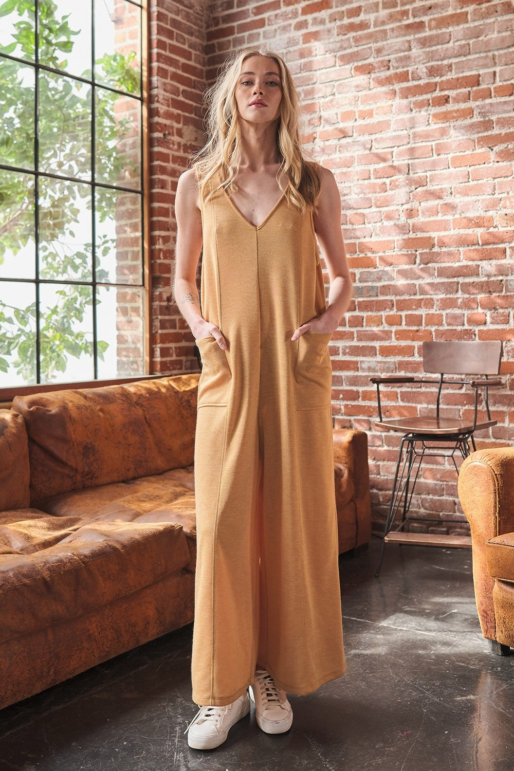 The V-Neck Sleeveless Wide Leg Jumpsuit is a chic wardrobe staple. The flattering v-neck design elongates the neckline for a slimming effect. With a sleeveless silhouette and wide leg pants, this jumpsuit offers a modern and sophisticated look. S - L
