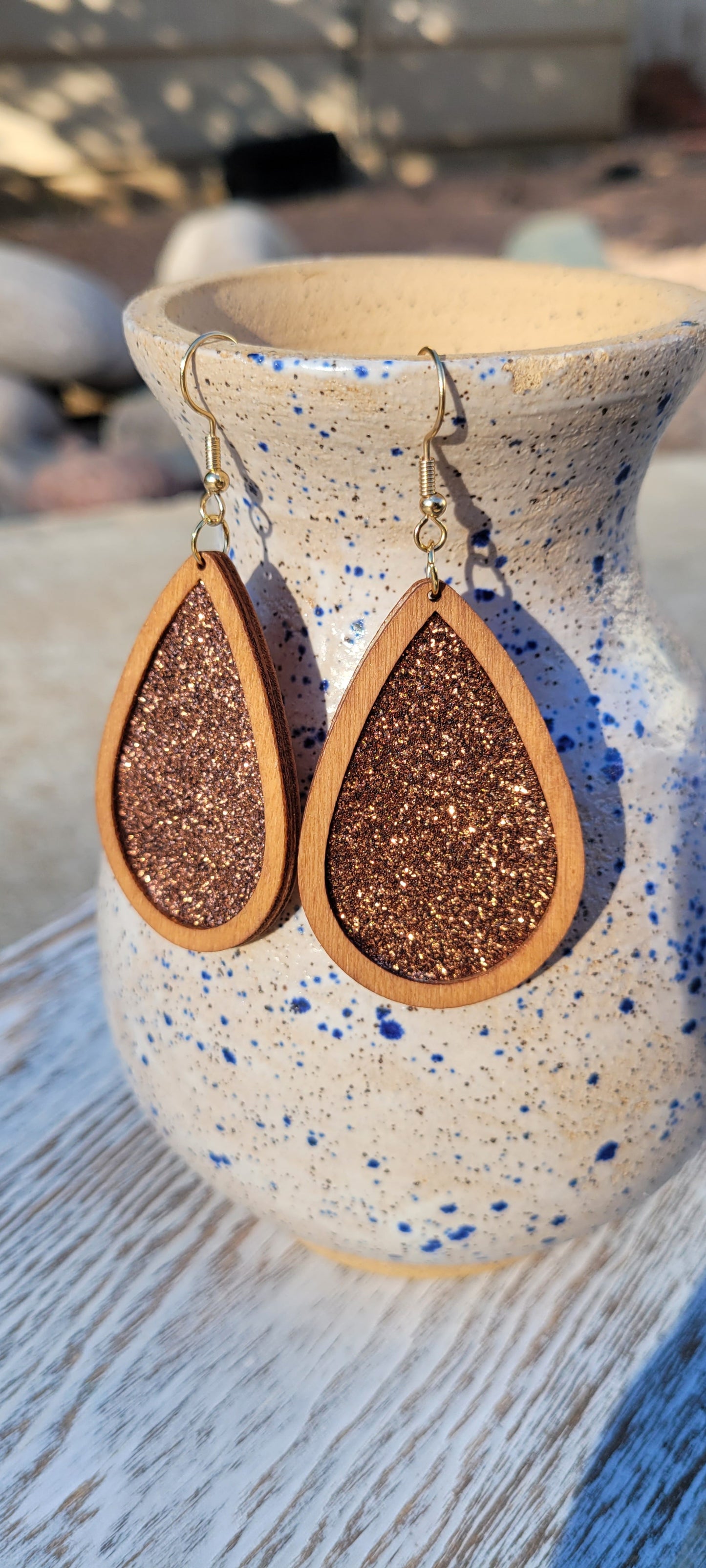 Light brown wood Cinnamon glitter Teardrop shape Brushed gold fish hook dangle earrings Rubber earring back Drop length 2”, width 1.33” Whether you want to be on the wild side or classy this earring set it will add a fun touch to your outfit