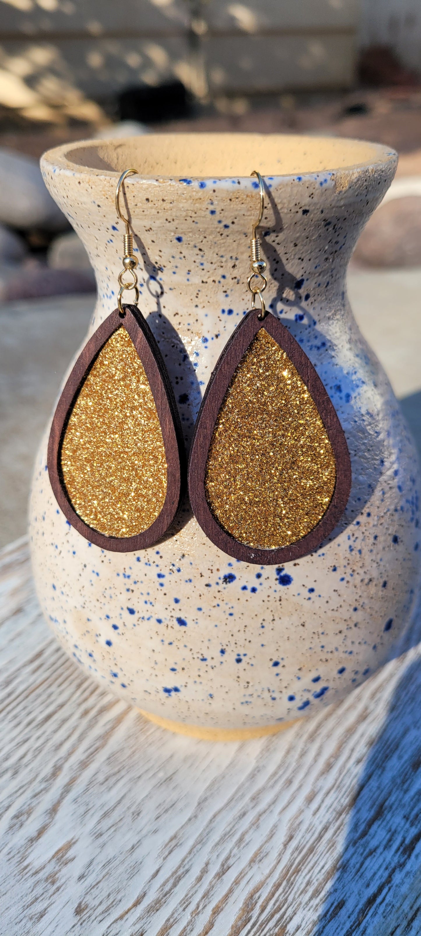 Dark brown wood Gold glitter Teardrop shape Brushed gold fish hook dangle earrings Rubber earring back Drop length 2”, width 1.33” Whether you want to be on the wild side or classy this earring set it will add a fun touch to your outfit