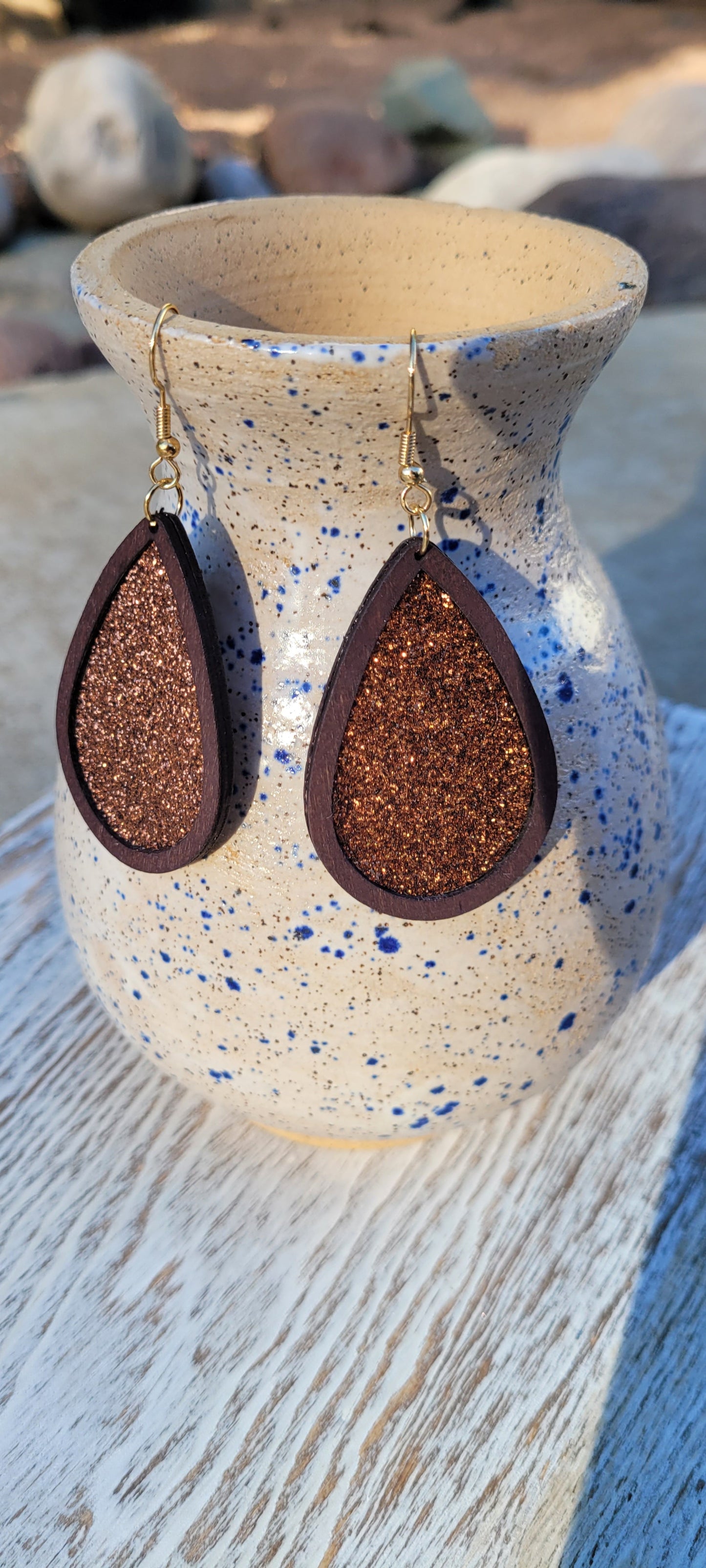 Dark brown wood Cinnamon glitter Teardrop shape Brushed gold fish hook dangle earrings Rubber earring back Drop length 2”, width 1.33” Whether you want to be on the wild side or classy this earring set it will add a fun touch to your outfit