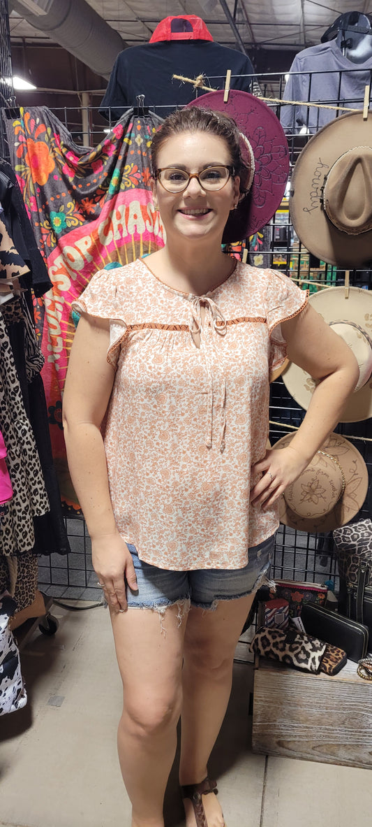 Dress to impress with this soft and dreamy "Tina Dusty Peach" top! With a split round neckline, a front tie with keyhole, flirty short sleeves, and a front chest-line lace, you'll look like you stepped out of a fairy tale. Puttin' the "wow" into every outfit! Sizes small through large.