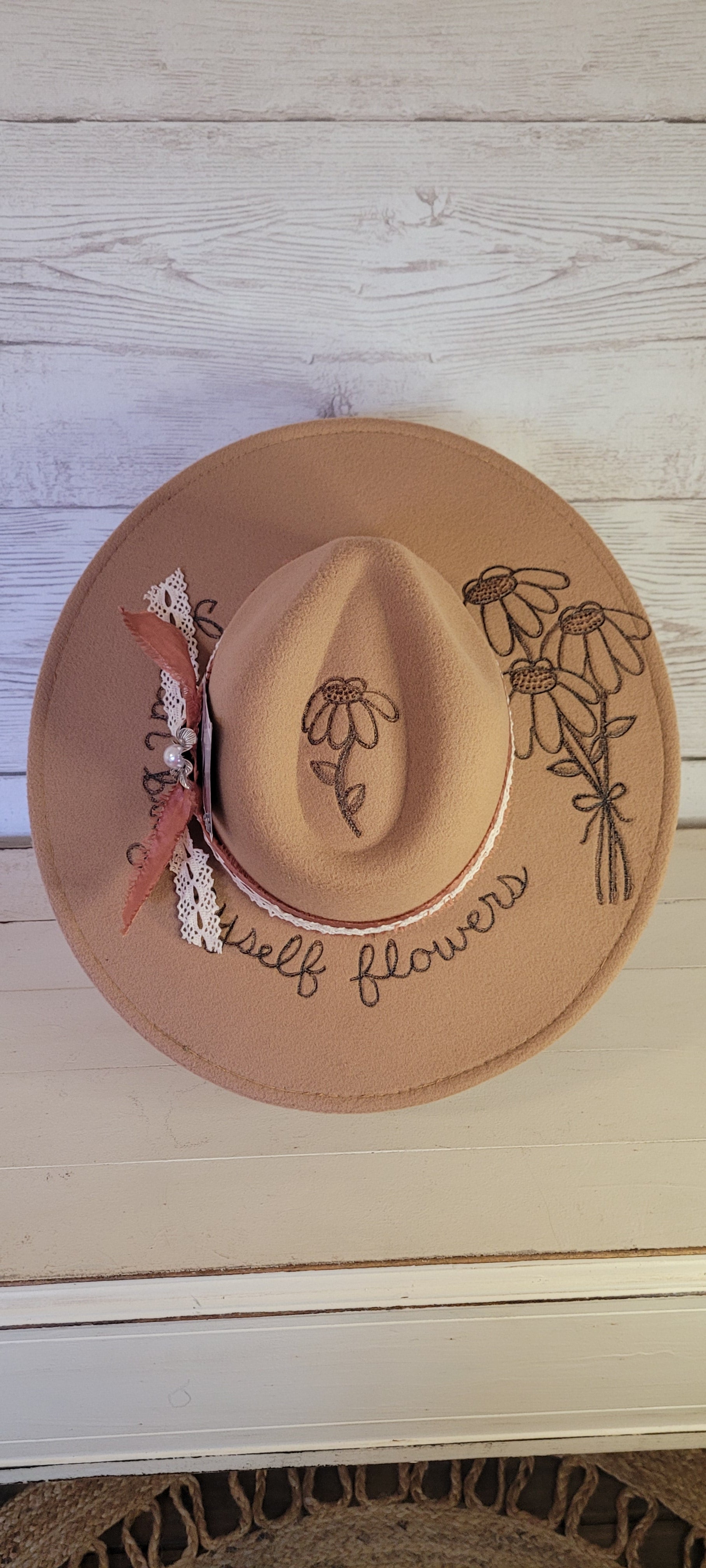 Features "I can by myself flowers" & flowers engraved Frayed rose ribbon, natural lace ribbon with flower brooch & playing card Felt hat Flat brim 65% polyester and 35% cotton Ribbon drawstring for hat size adjustment Head Circumference: 24" Crown Height: 5" Brim Length: 15.75" Brim Width: 14.5" Branded & numbered inside crown Custom burned & engraved by Kayla