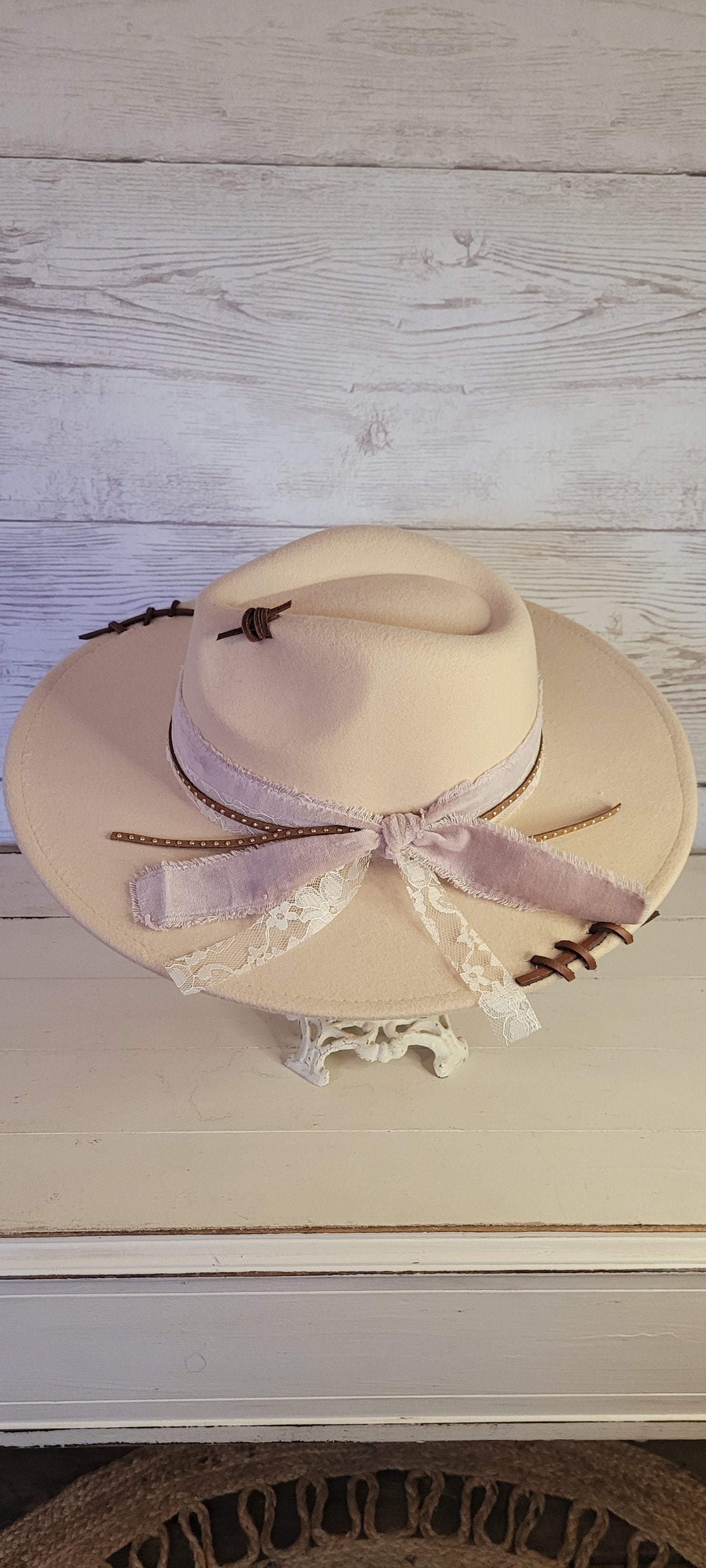 Features velvet mushroom ribbon, lace ribbon, leather band with metal detailing, & leather sewn into brim & crown Felt hat Flat brim 65% polyester and 35% cotton Ribbon drawstring for hat size adjustment Head Circumference: 24" Crown Height: 5" Brim Length: 15.75" Brim Width: 14.5" Branded & numbered inside crown Custom designed by Kayla