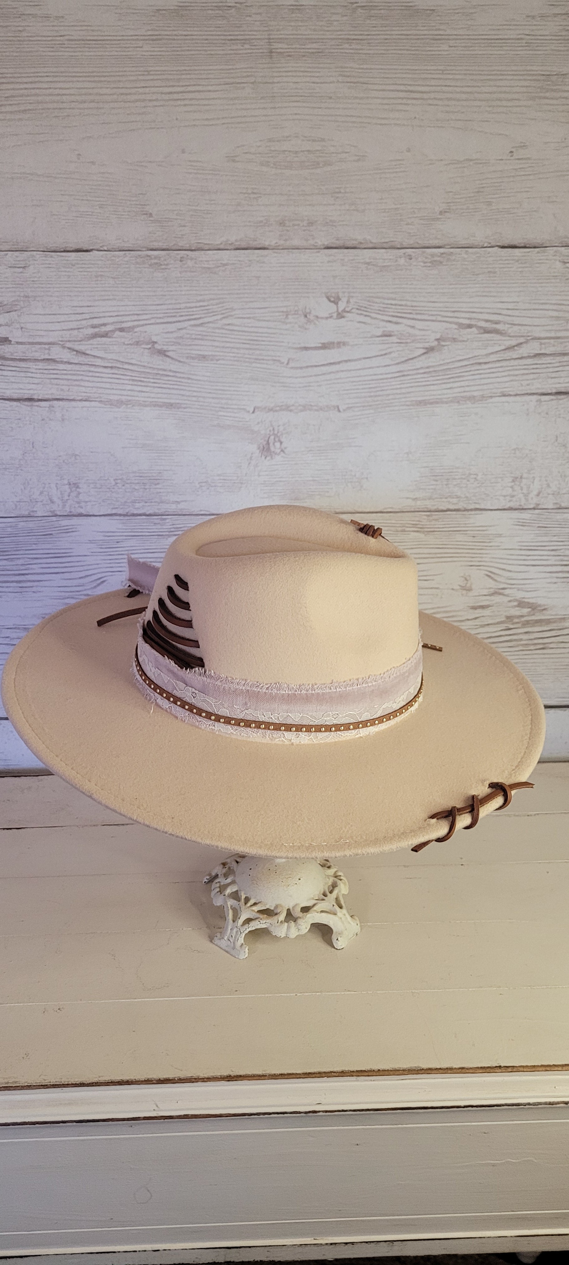 Features velvet mushroom ribbon, lace ribbon, leather band with metal detailing, & leather sewn into brim & crown Felt hat Flat brim 65% polyester and 35% cotton Ribbon drawstring for hat size adjustment Head Circumference: 24" Crown Height: 5" Brim Length: 15.75" Brim Width: 14.5" Branded & numbered inside crown Custom designed by Kayla