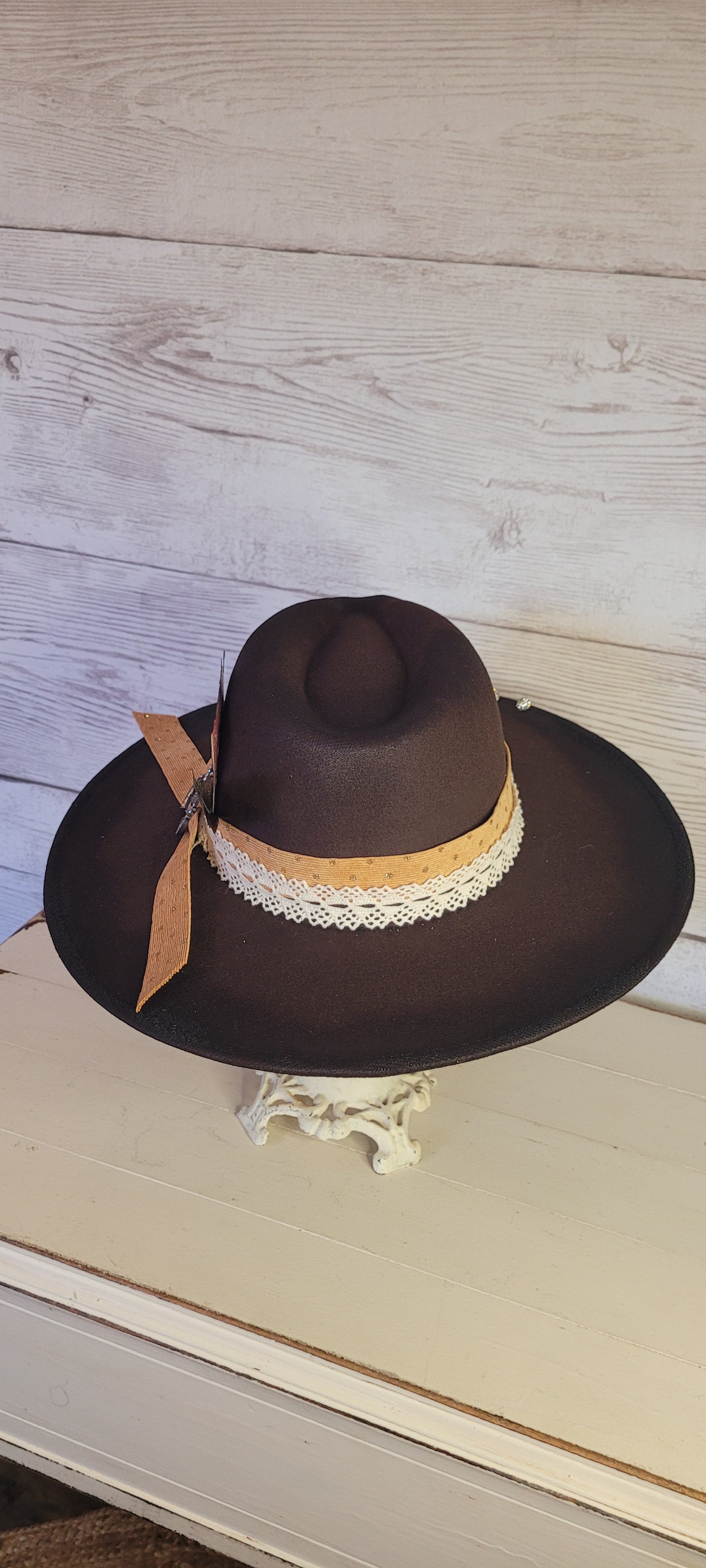Features natural lace ribbon, corduroy ribbon, feather, playing cards, pistol brooch, & rhinestone beads Felt hat Flat brim 65% polyester and 35% cotton Ribbon drawstring for hat size adjustment Head Circumference: 24" Crown Height: 5" Brim Length: 15.75" Brim Width: 14.5" Branded & numbered inside crown Custom designed by Kayla