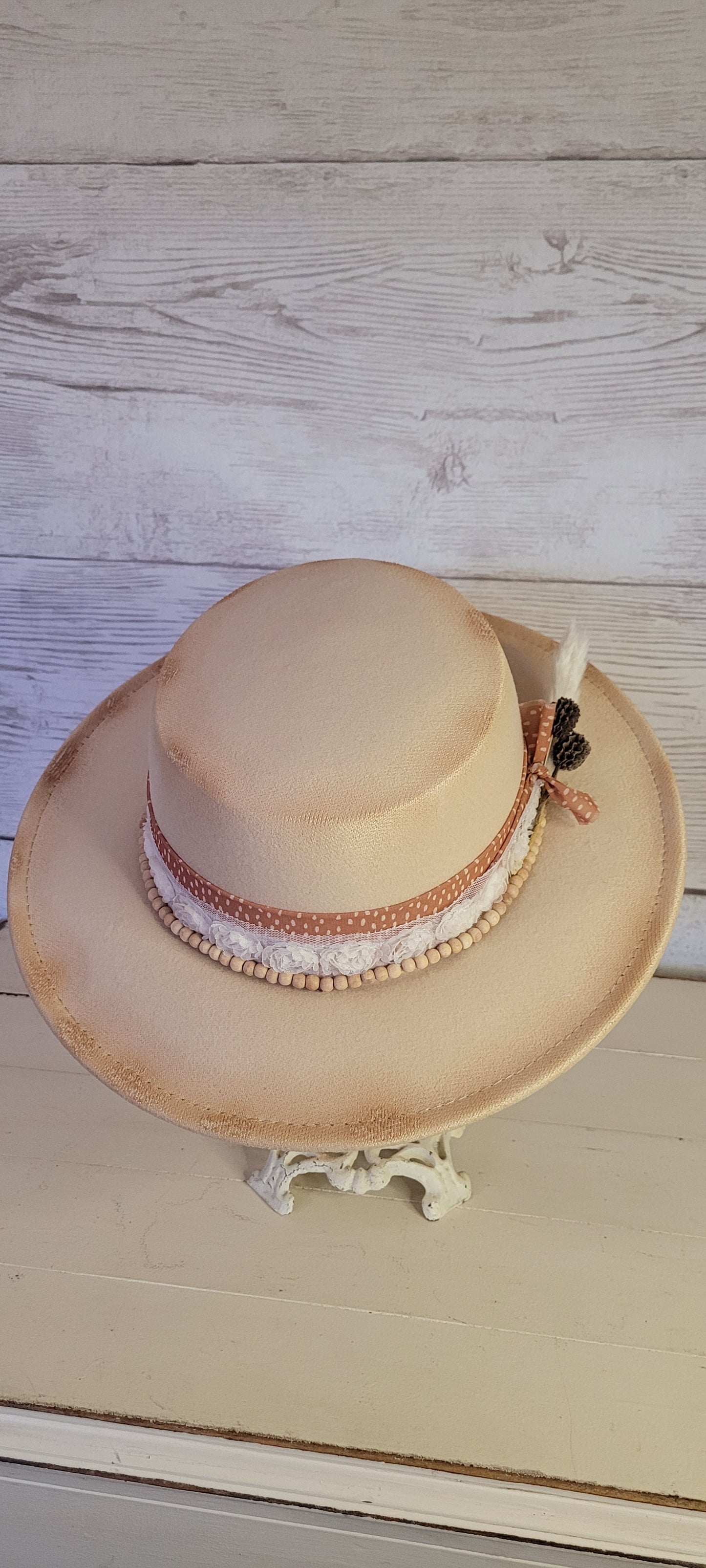 Sheer ribbon, flower ribbon, wooden bead band, pine cones & pampas Felt hat Flat brim 100% polyester Ribbon drawstring for hat size adjustment Head Circumference: 24" Crown Height: 3.5" Brim Length: 13.5" Brim Width: 12.75" Branded & numbered inside crown Custom burned by Kayla