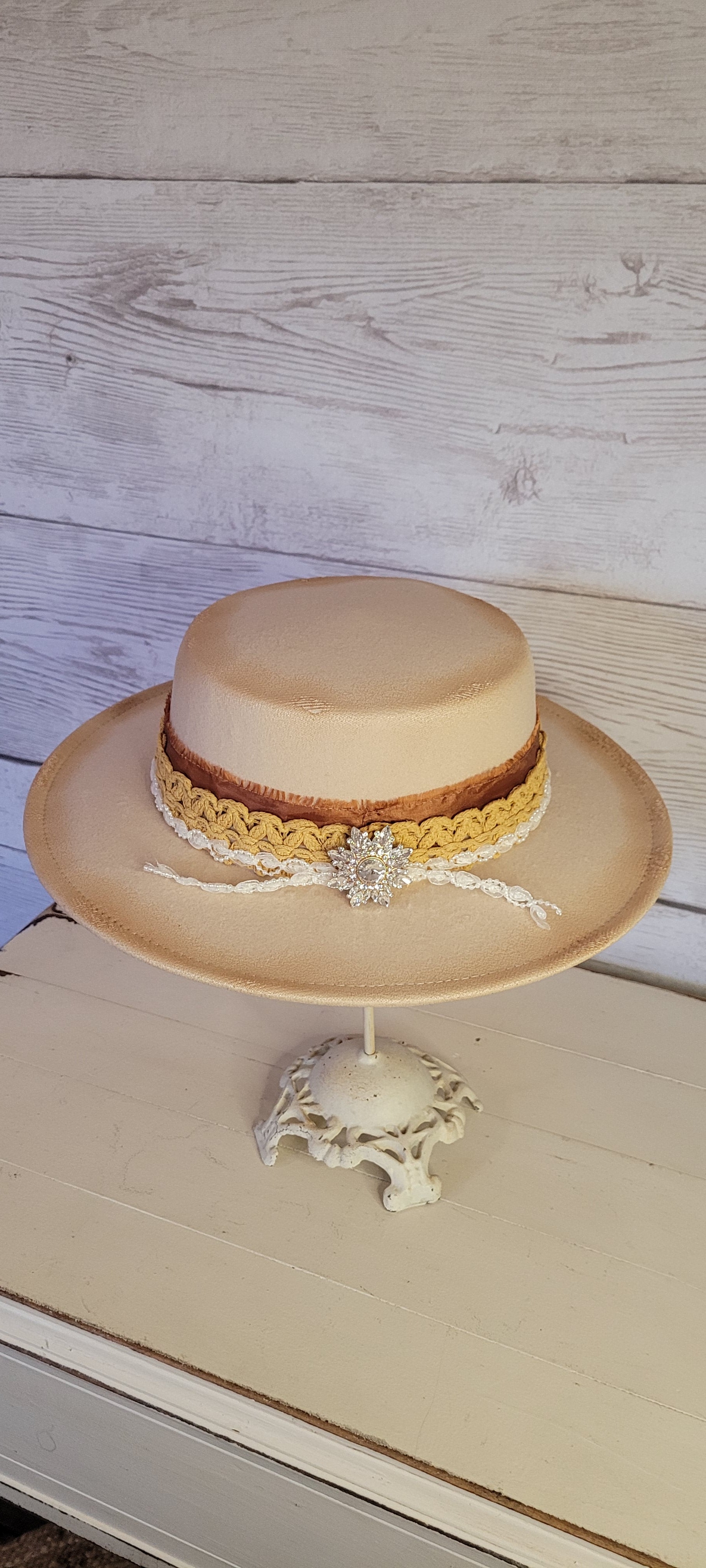 Lace ribbon, frayed lace ribbon, pearl lace ribbon, and rhinestone crystal brooch Felt hat Flat brim 100% polyester Ribbon drawstring for hat size adjustment Head Circumference: 24" Crown Height: 3.5" Brim Length: 13.5" Brim Width: 12.75" Branded & numbered inside crown Custom burned by Kayla