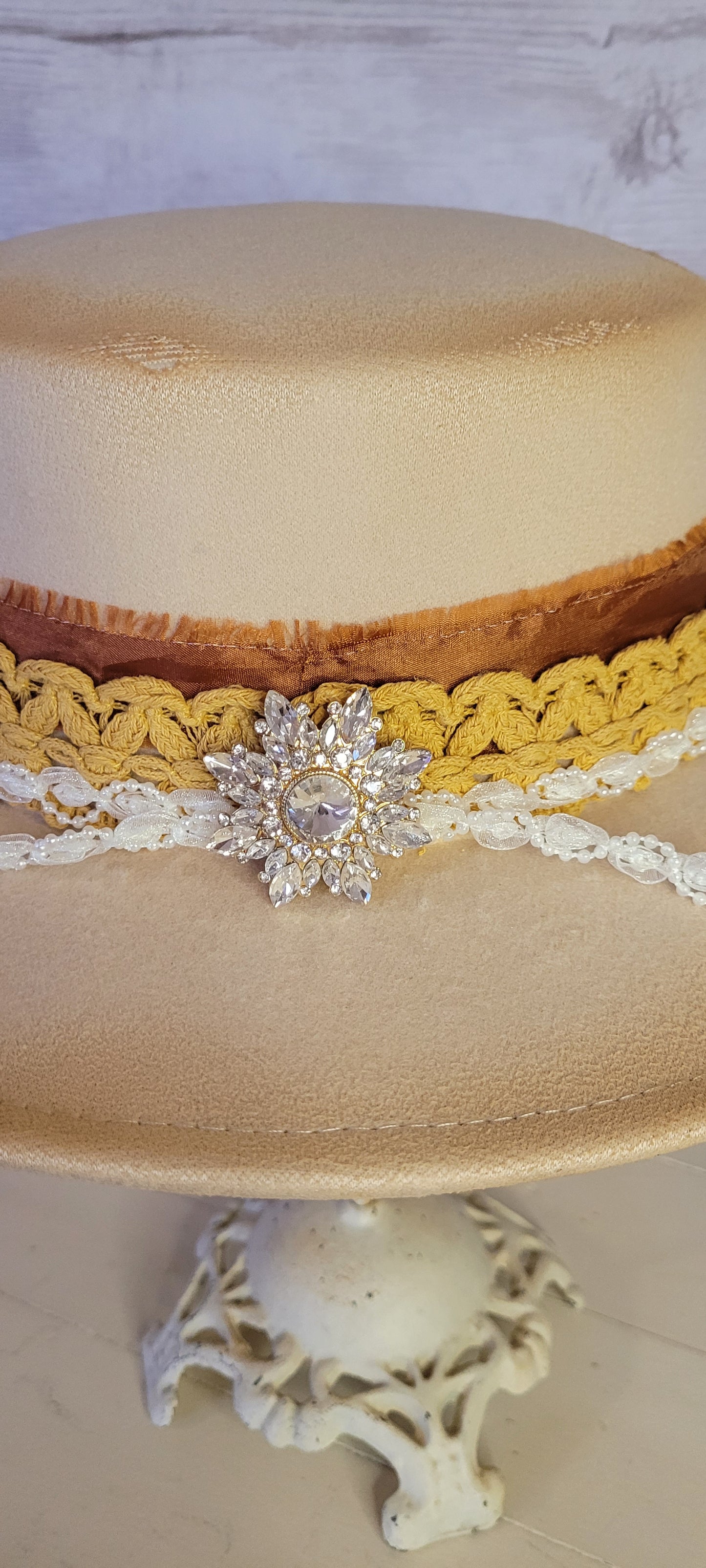 Lace ribbon, frayed lace ribbon, pearl lace ribbon, and rhinestone crystal brooch Felt hat Flat brim 100% polyester Ribbon drawstring for hat size adjustment Head Circumference: 24" Crown Height: 3.5" Brim Length: 13.5" Brim Width: 12.75" Branded & numbered inside crown Custom burned by Kayla