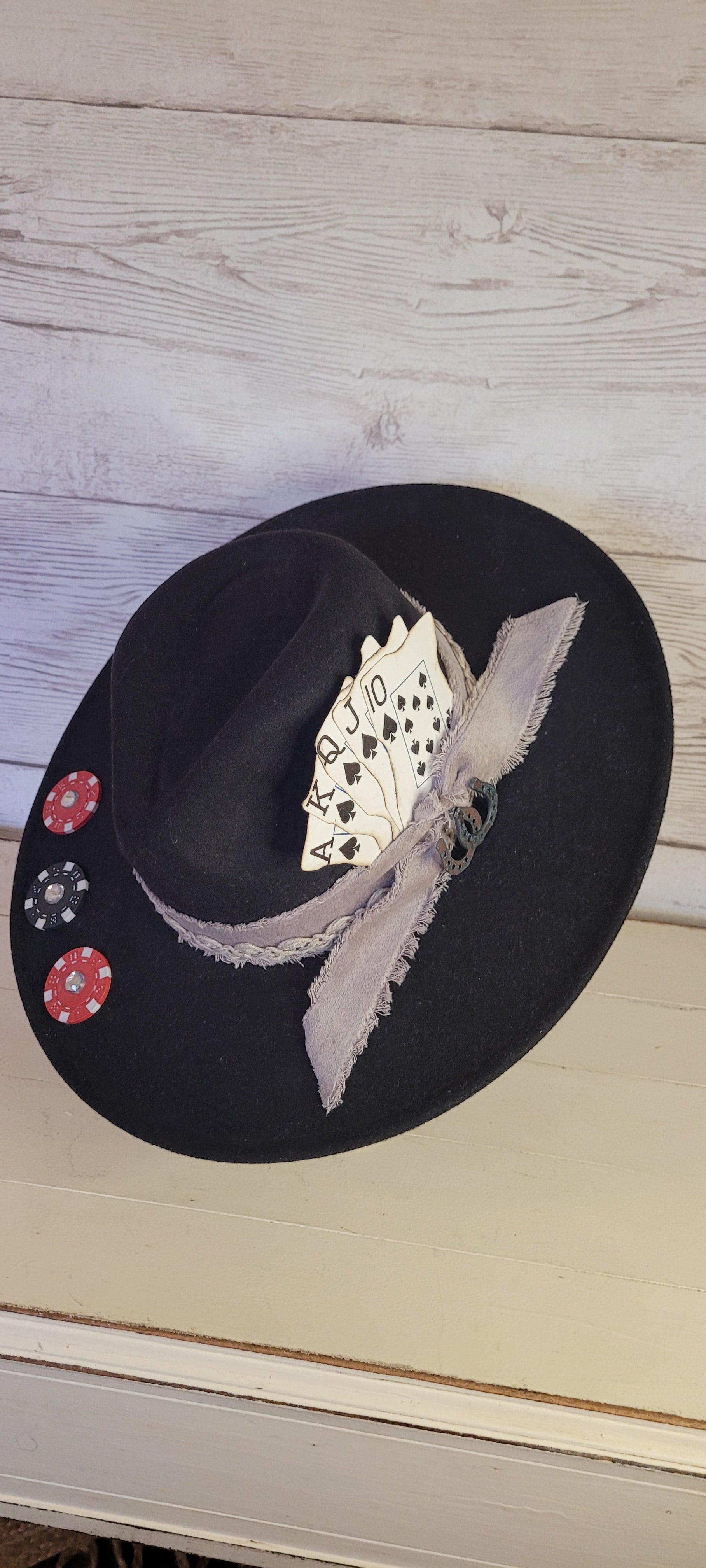 Features poker chips, dice, rhinestones, playing cards, natural frayed & lace ribbon, & metal horseshoe Felt hat Flat brim 35% cotton and 65% polyester Ribbon drawstring for hat size adjustment Head Circumference: 24" Crown Height: 5" Brim Length: 15.75" Brim Width: 14.5" Branded & numbered inside crown Custom designed by Kayla