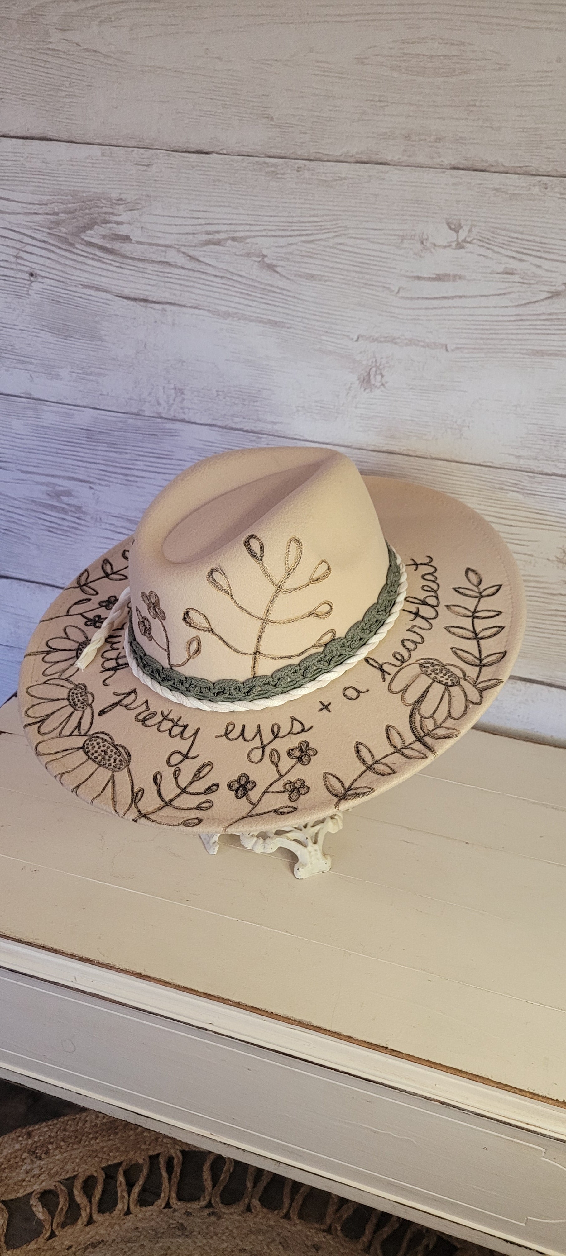 Features engraved whimsical flowers & plants Felt hat Flat brim 65% polyester and 35% cotton Ribbon drawstring for hat size adjustment Head Circumference: 25" H:5.25" L:16" W:14.5" Head Circumference: 24" Crown Height: 5" Brim Length: 15.75" Brim Width: 14.5" Branded & numbered inside crown Custom engraved by Kayla