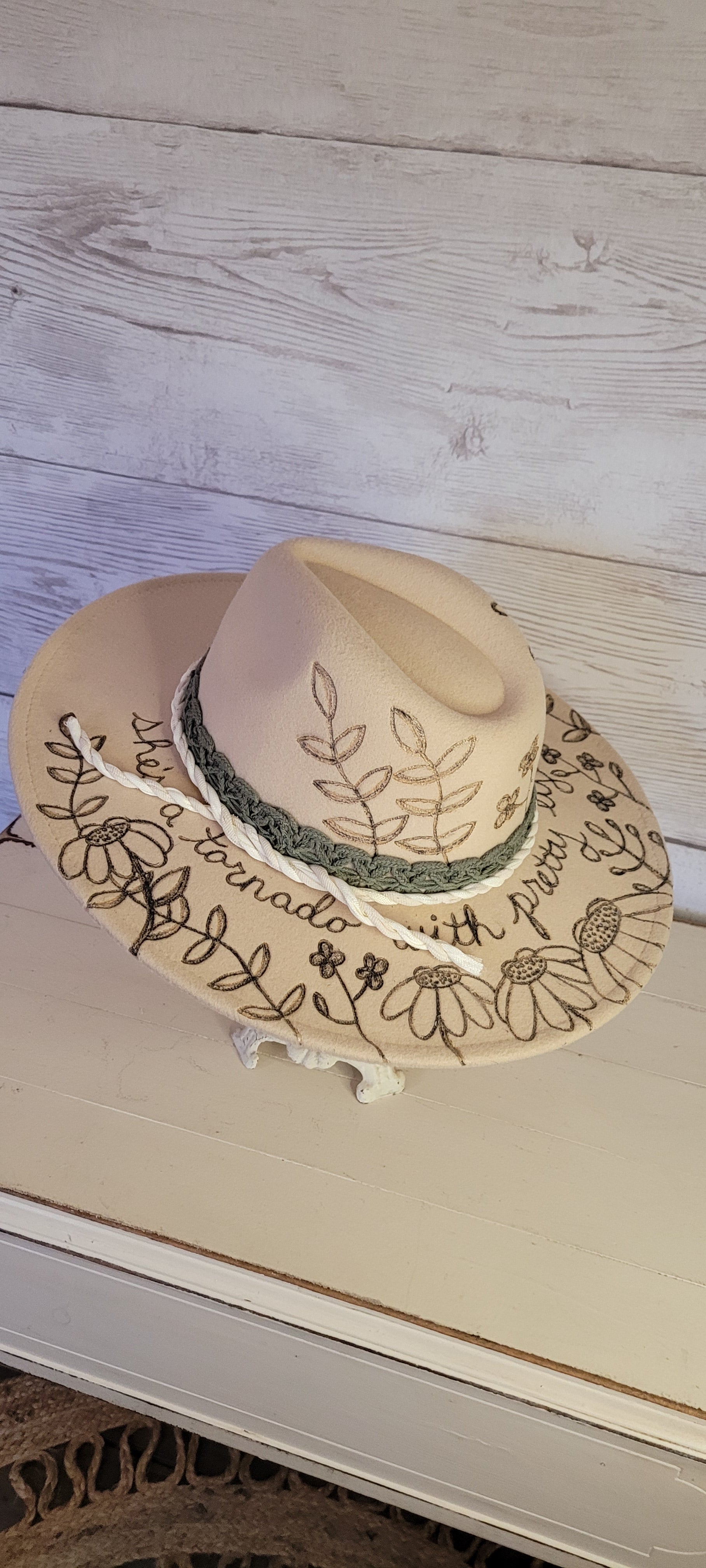 Custom engraved by Kayla Features whimsical flowers Ivory brim hat fedora style Felt hat Flat brim 65% polyester and 35% cotton Ribbon drawstring for hat size adjustment Head Circumference: 25" H:5.25" L:16" W:14.5"