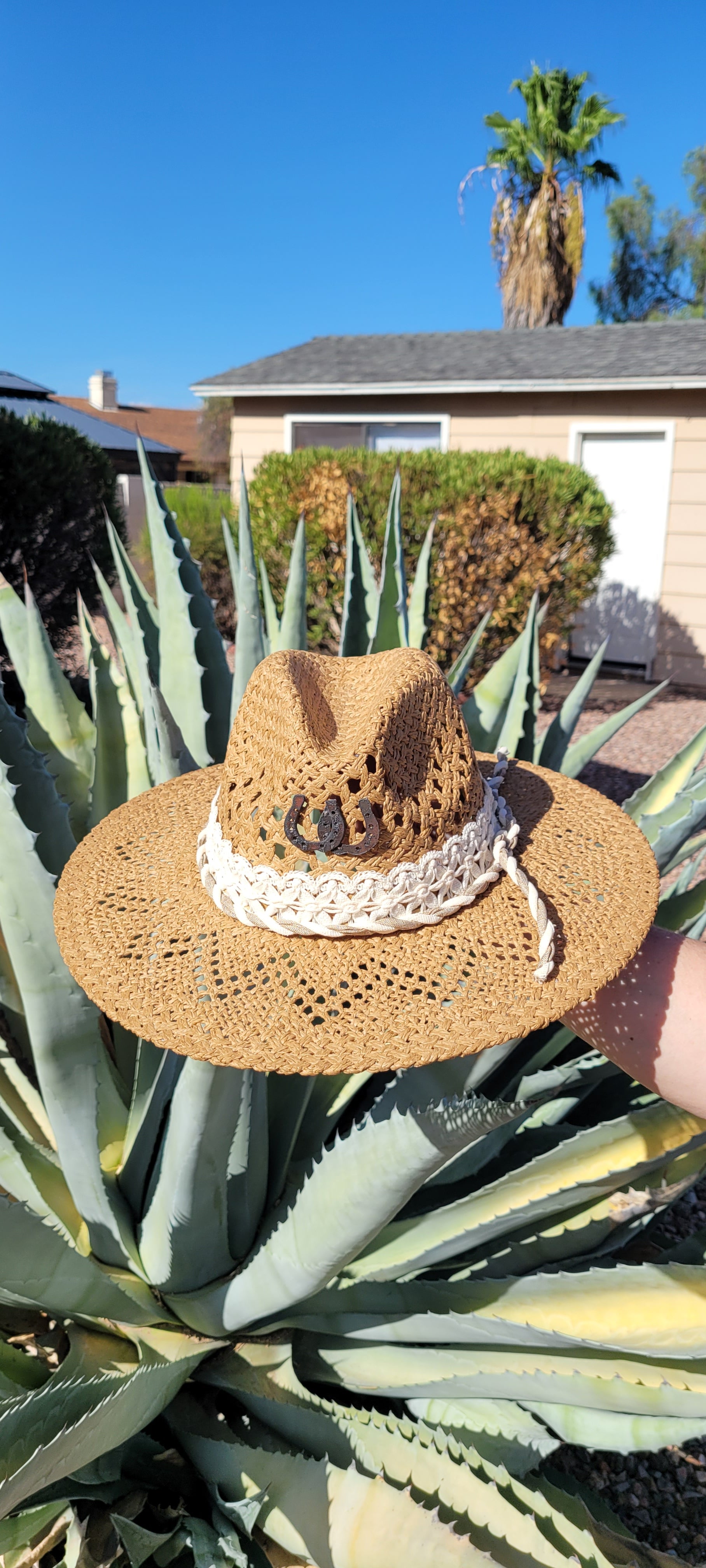 Lace ribbon, twisted gauze, metal horseshoes Straw hat Flat brim 65% polyester and 35% cotton Ribbon drawstring for hat size adjustment Head Circumference: 24" Crown Height: 5" Brim Length: 15.75" Brim Width: 14.75" Branded & numbered inside crown Custom designed by Kayla
