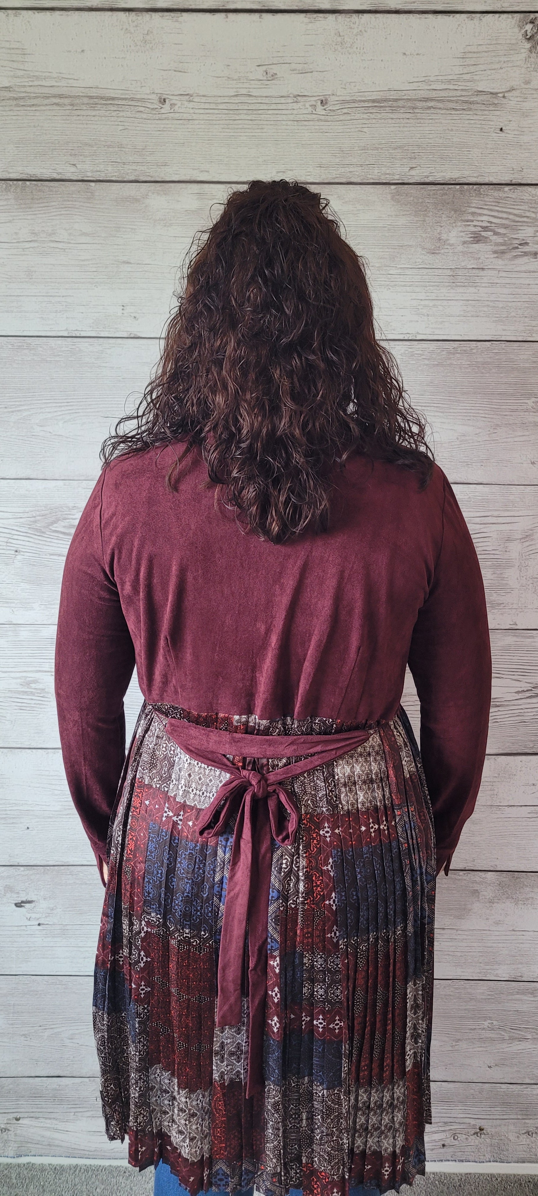 Rock that western flair with Julianna, an ultra-cool mix media cardigan. This burgundy faux suede number will have you feeling fancy with its pleated bottom, long sleeve, and tie strap around the waist. You'll be all set for a night out on the town! Sizes small through large.